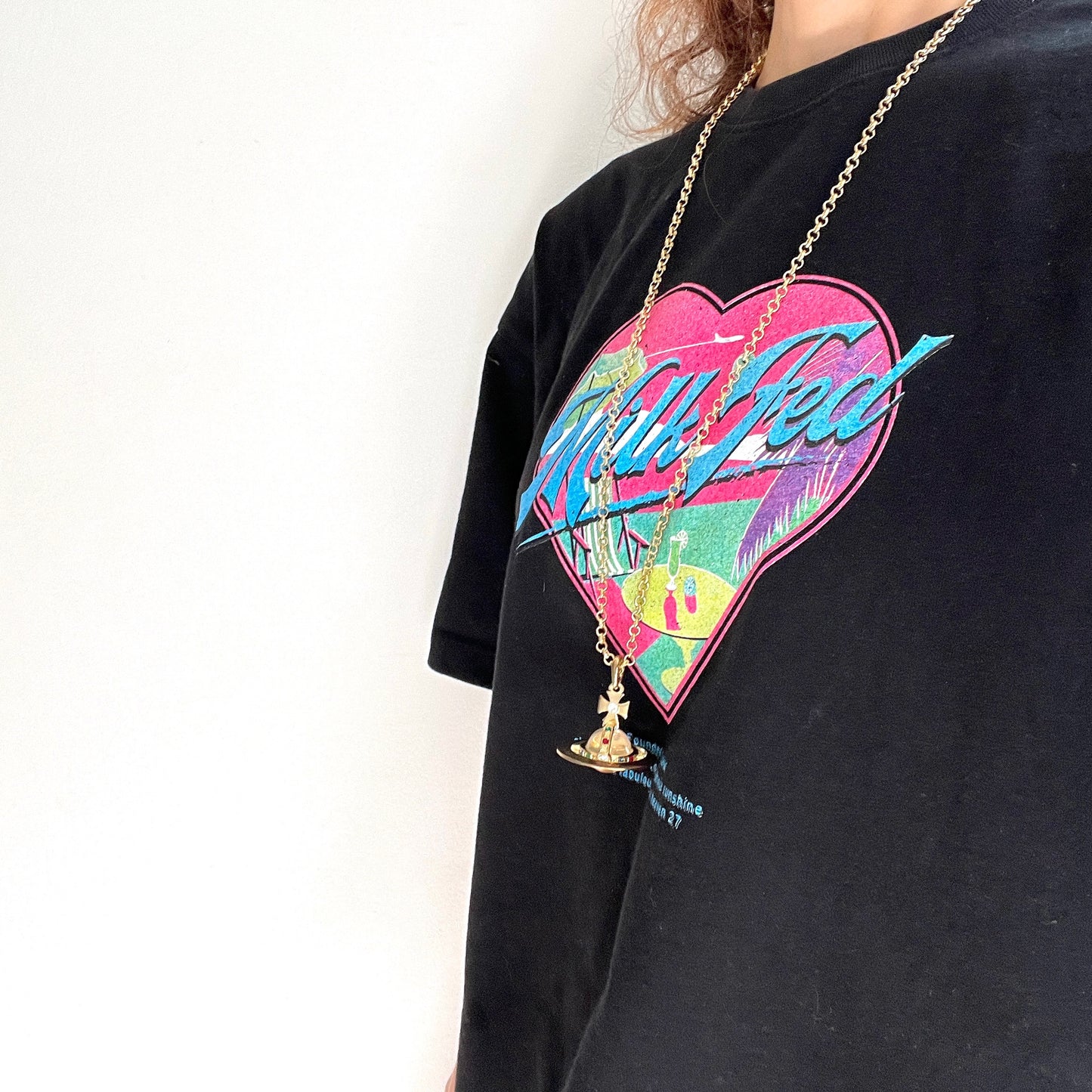A striking pendant necklace featuring a decorative orb encircled by a metal hoop, resembling the rings of Saturn. カラフルなストーンで飾られた宝珠(キリスト教圏で、十字架をのせた球体として王権の象徴に用いられるモチーフ)を、まるで土星の輪のようなメタルフープで囲んだデザインのペンダントネックレスです。