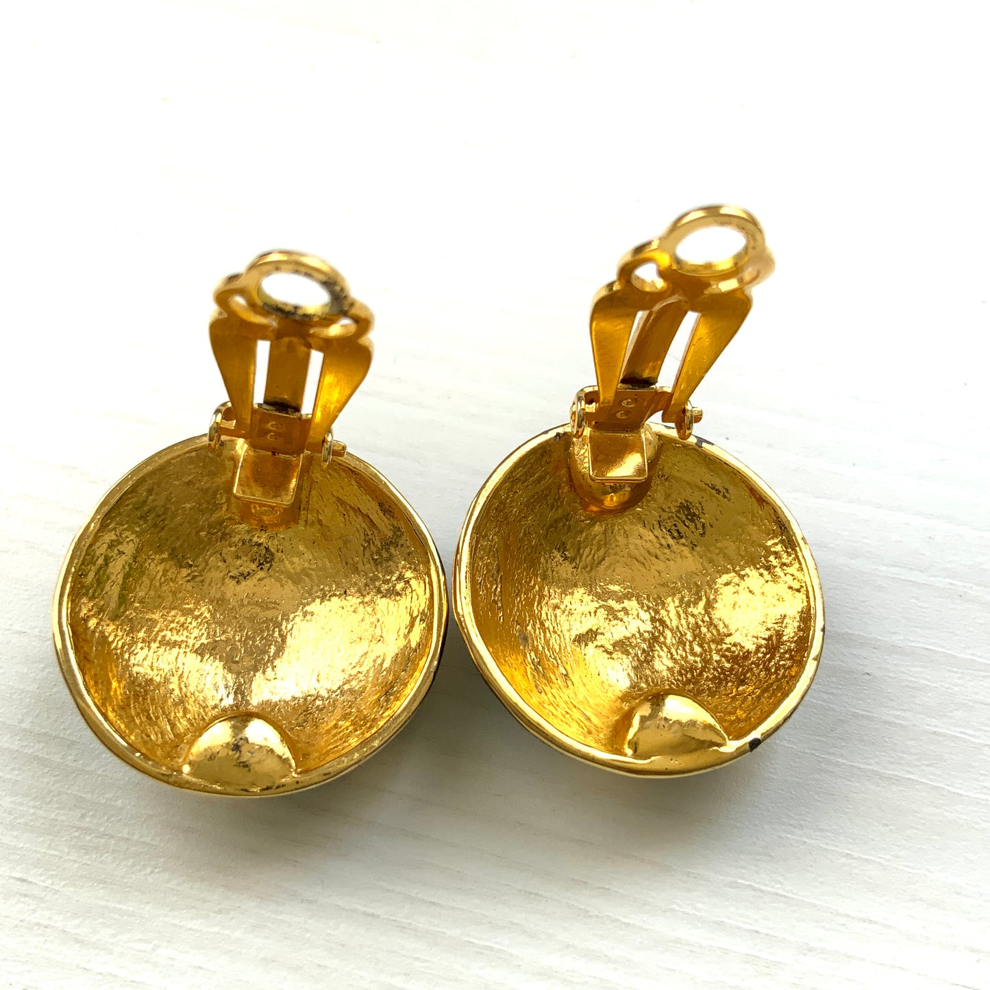Clip-on earrings featuring a globe design with gold tone continents over a dome of deep ocean blue enamel. 深い海の色のエナメルドームにゴールドトーンで大陸をあしらった地球のクリップイヤリング。