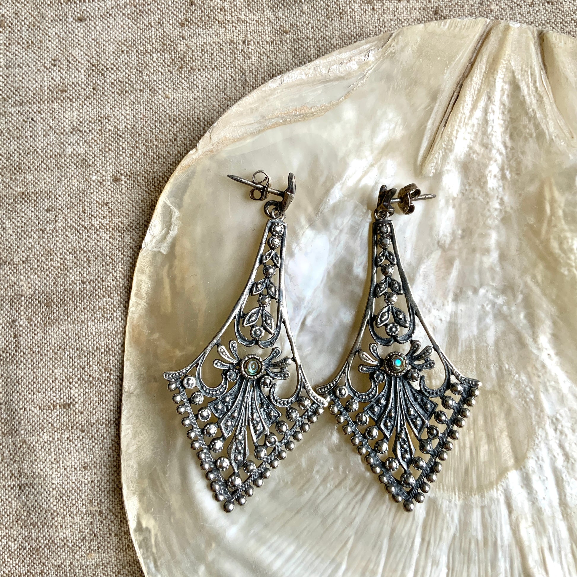 A pair of silver dangle earrings featuring beautiful openwork detailing. 美しいオープンワークが施されたシルバーのダングル ピアス。