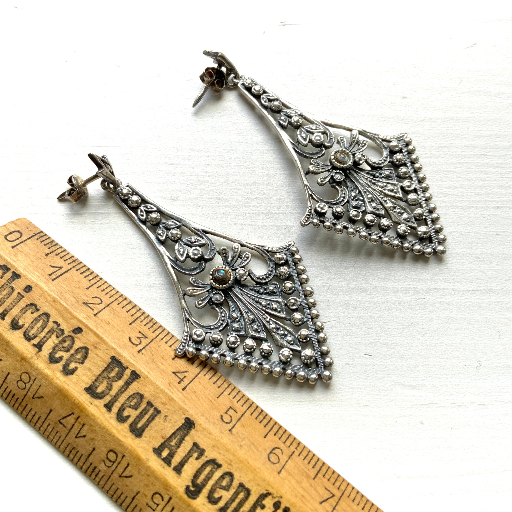 A pair of silver dangle earrings featuring beautiful openwork detailing. 美しいオープンワークが施されたシルバーのダングル ピアス。
