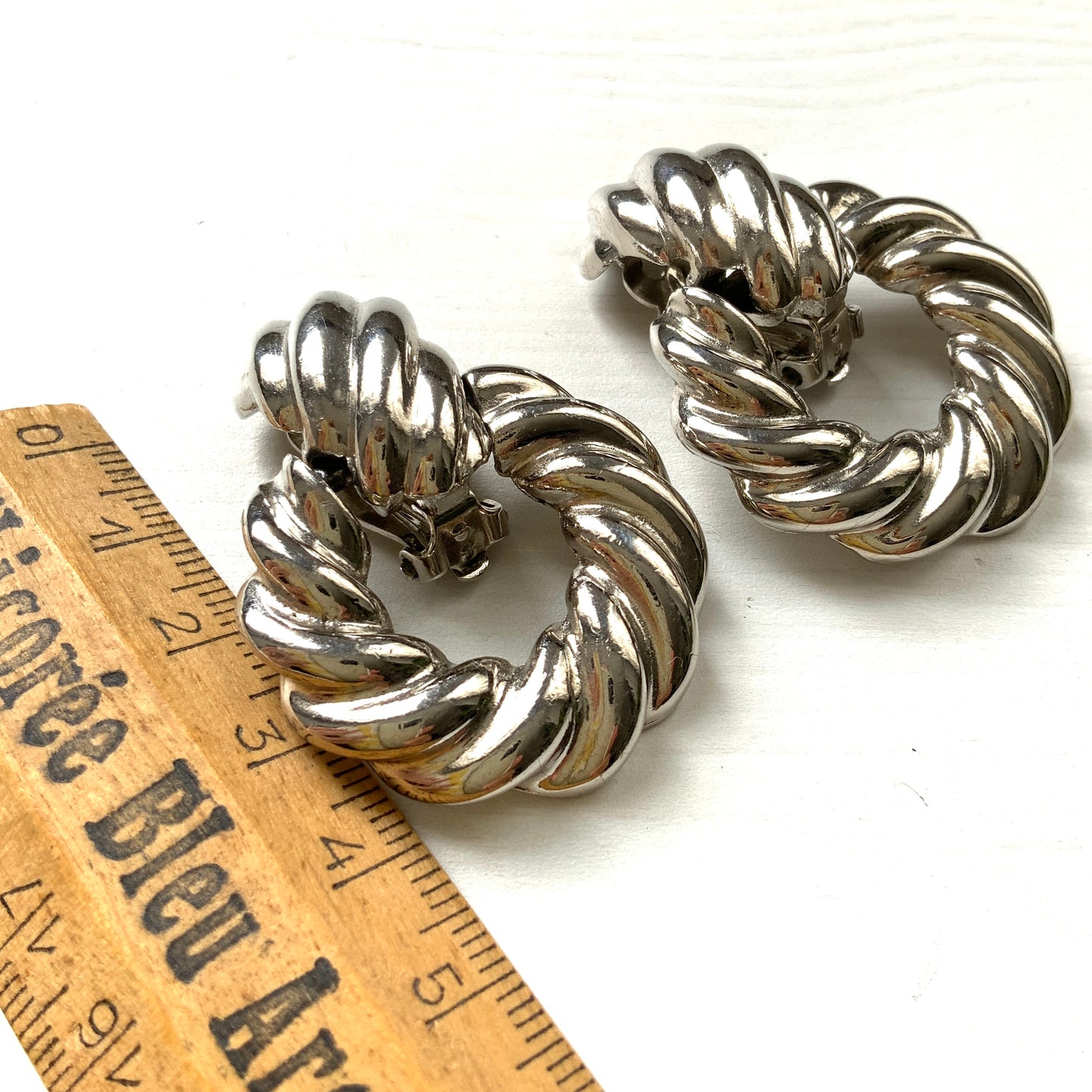 Twisted silver-tone metal door knocker-style clip-on earrings. ツイストされたシルバートーンメタルのドアノッカー型クリップイヤリング。