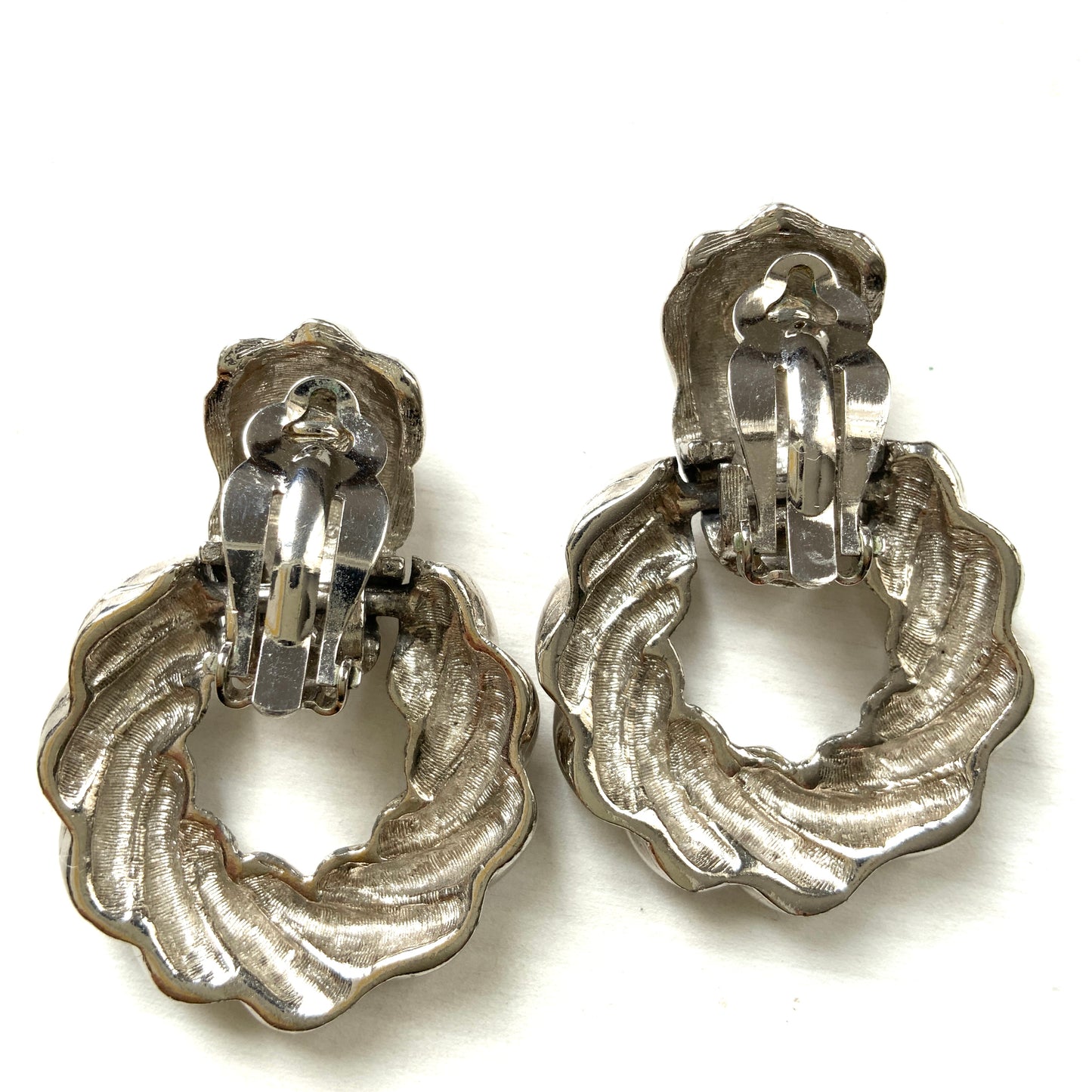 Twisted silver-tone metal door knocker-style clip-on earrings. ツイストされたシルバートーンメタルのドアノッカー型クリップイヤリング。