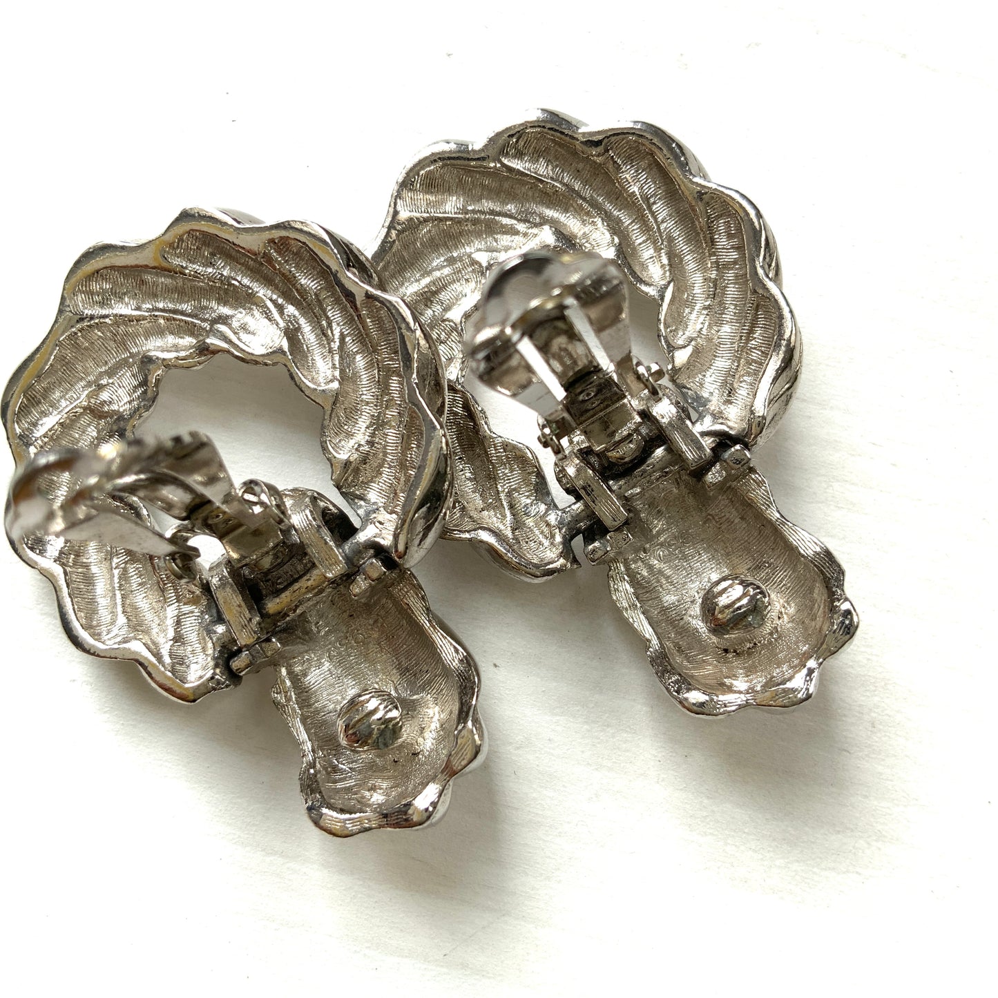 Twisted silver-tone metal door knocker-style clip-on earrings. ツイストされたシルバートーンメタルのドアノッカー型クリップイヤリング。