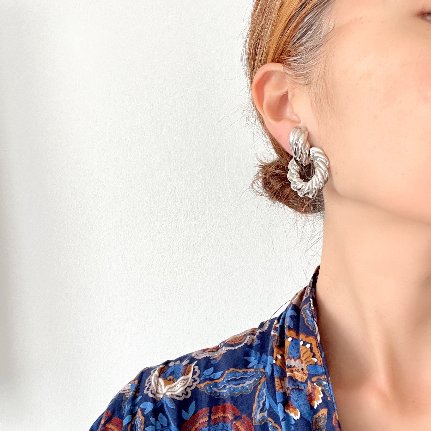 Twisted silver-tone metal door knocker-style clip-on earrings. ツイストされたシルバートーンメタルのドアノッカー型クリップイヤリング。