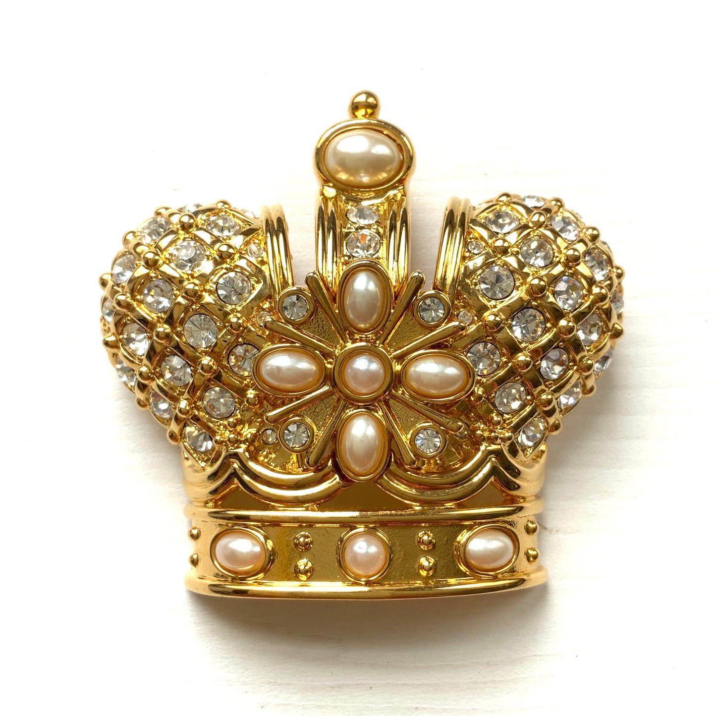 A crown brooch adorned with pearl cabochons and clear rhinestones on gold-tone metal. ゴールドトーンメタルに、パールカボションやクリアラインストーンがふんだんにあしらわれたクラウンブローチ。