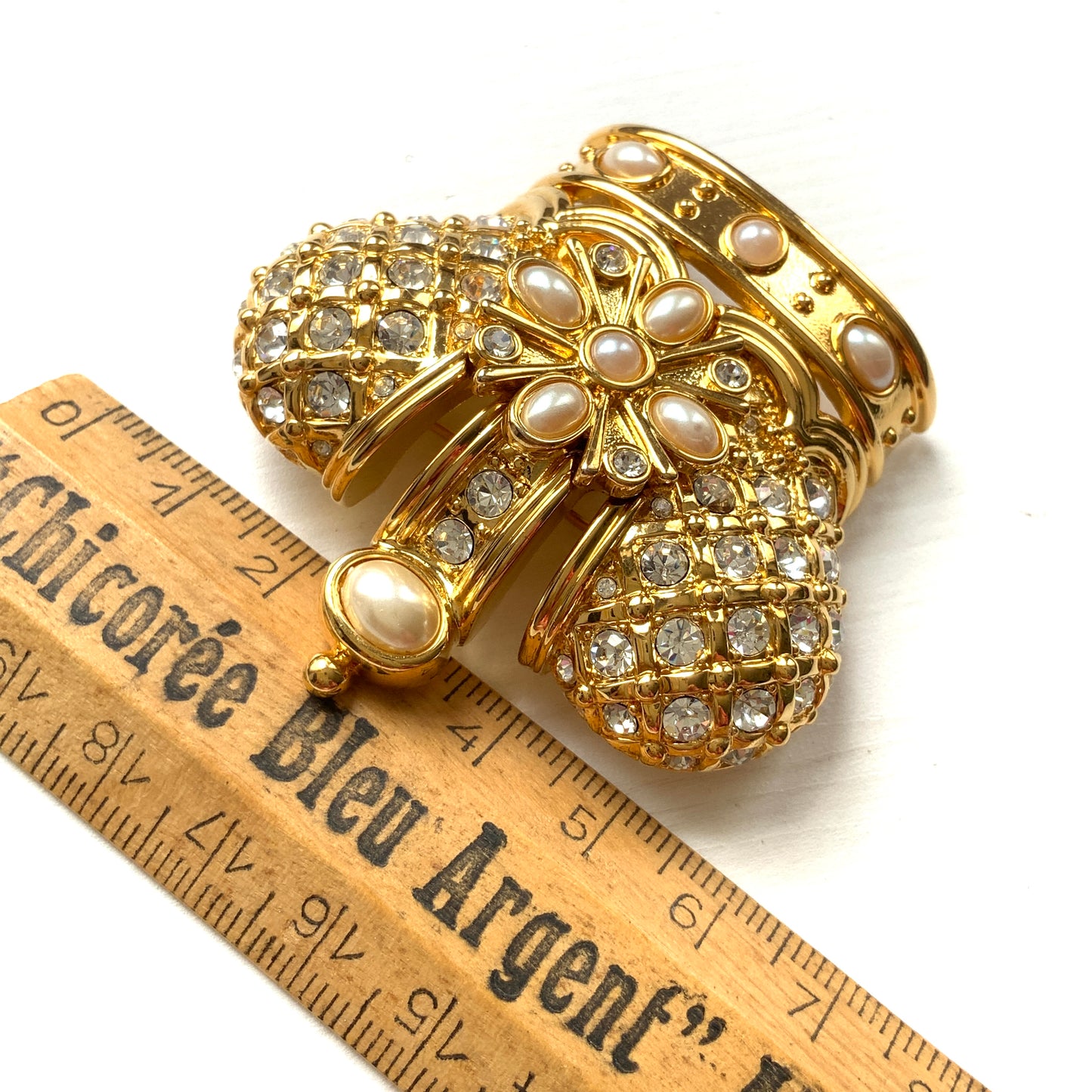 A crown brooch adorned with pearl cabochons and clear rhinestones on gold-tone metal. ゴールドトーンメタルに、パールカボションやクリアラインストーンがふんだんにあしらわれたクラウンブローチ。