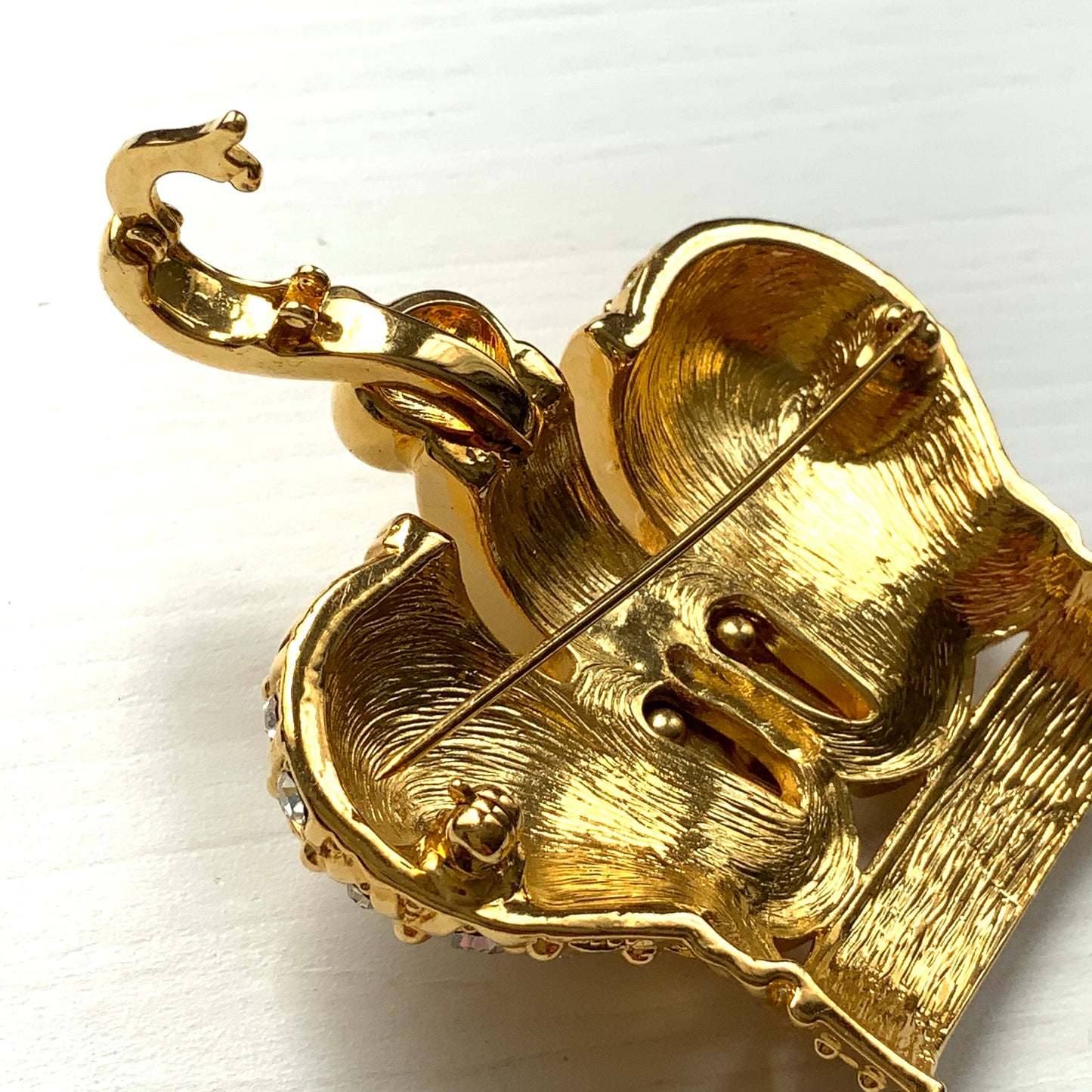 A crown brooch adorned with pearl cabochons and clear rhinestones on gold-tone metal. ゴールドトーンメタルに、パールカボションやクリアラインストーンがふんだんにあしらわれたクラウンブローチ。