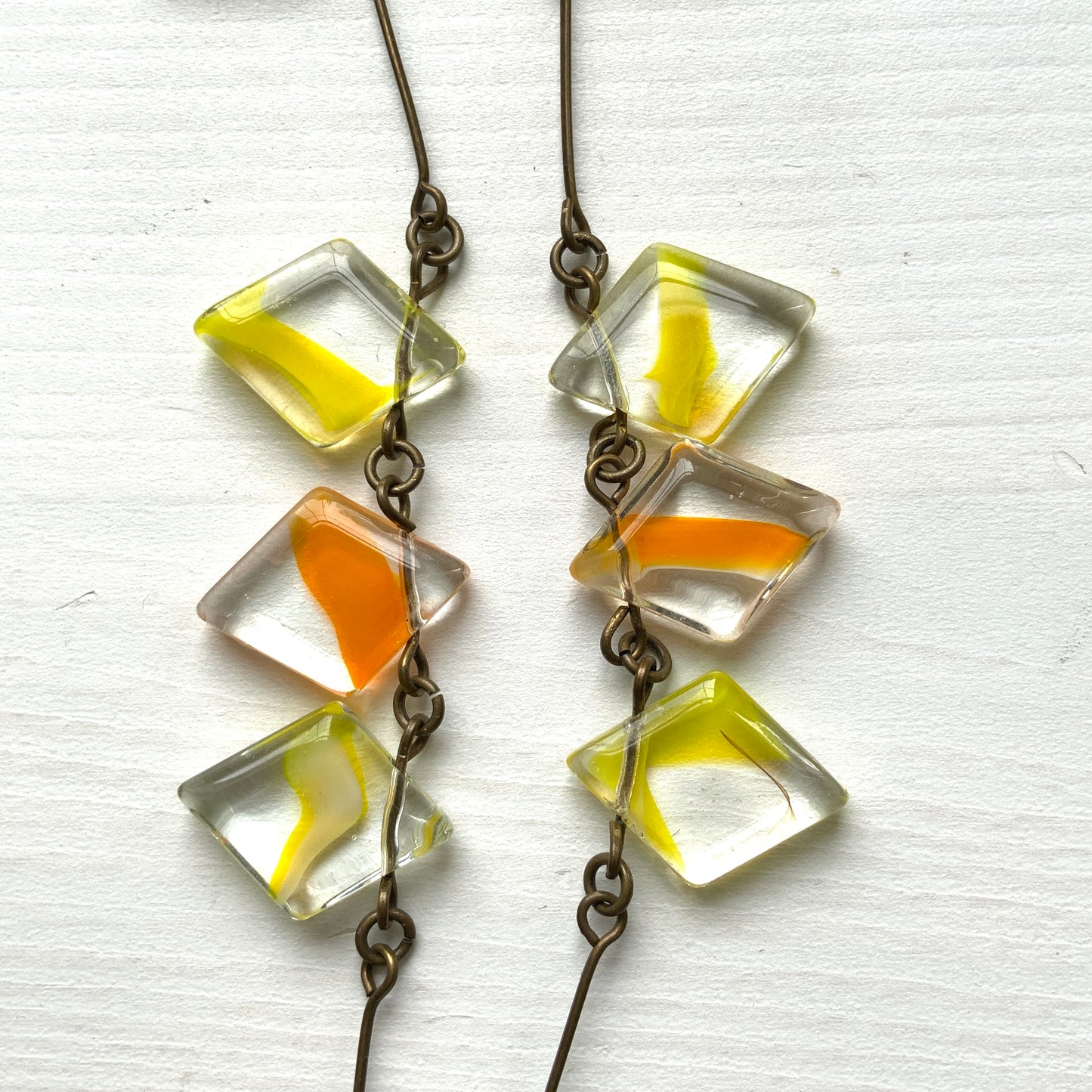 Necklace featuring diamond-shaped clear glass beads infused with shades of yellow, orange, and white. クリアのダイヤ型グラスにイエロー、オレンジ、ホワイトのカラーが入ったビーズを使ったネックレス。