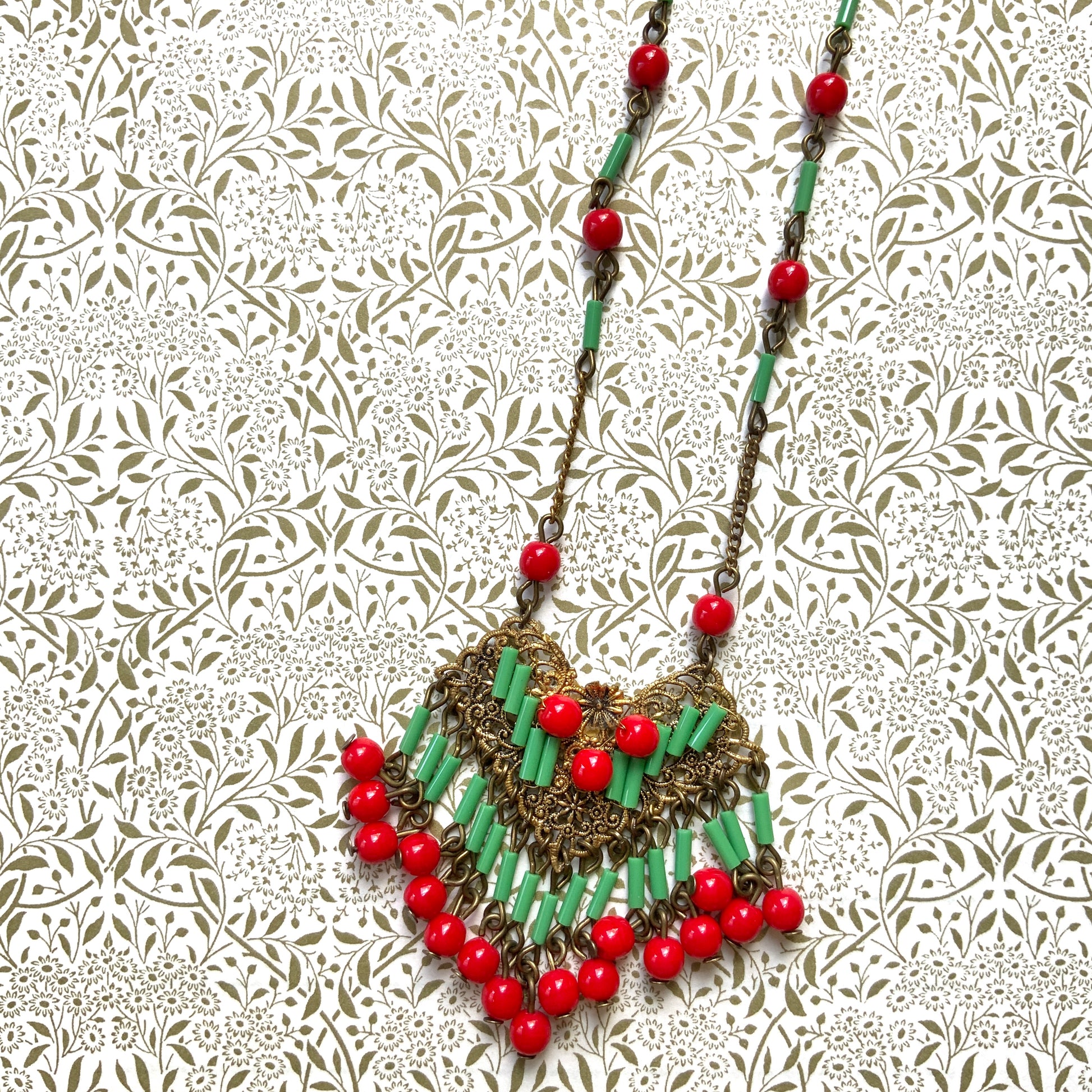 A necklace adorned with vivid red and yellow-green glass that sways with every movement. ヴィヴィッドなレッドとイエローグリーンのグラスがゆれるネックレス。