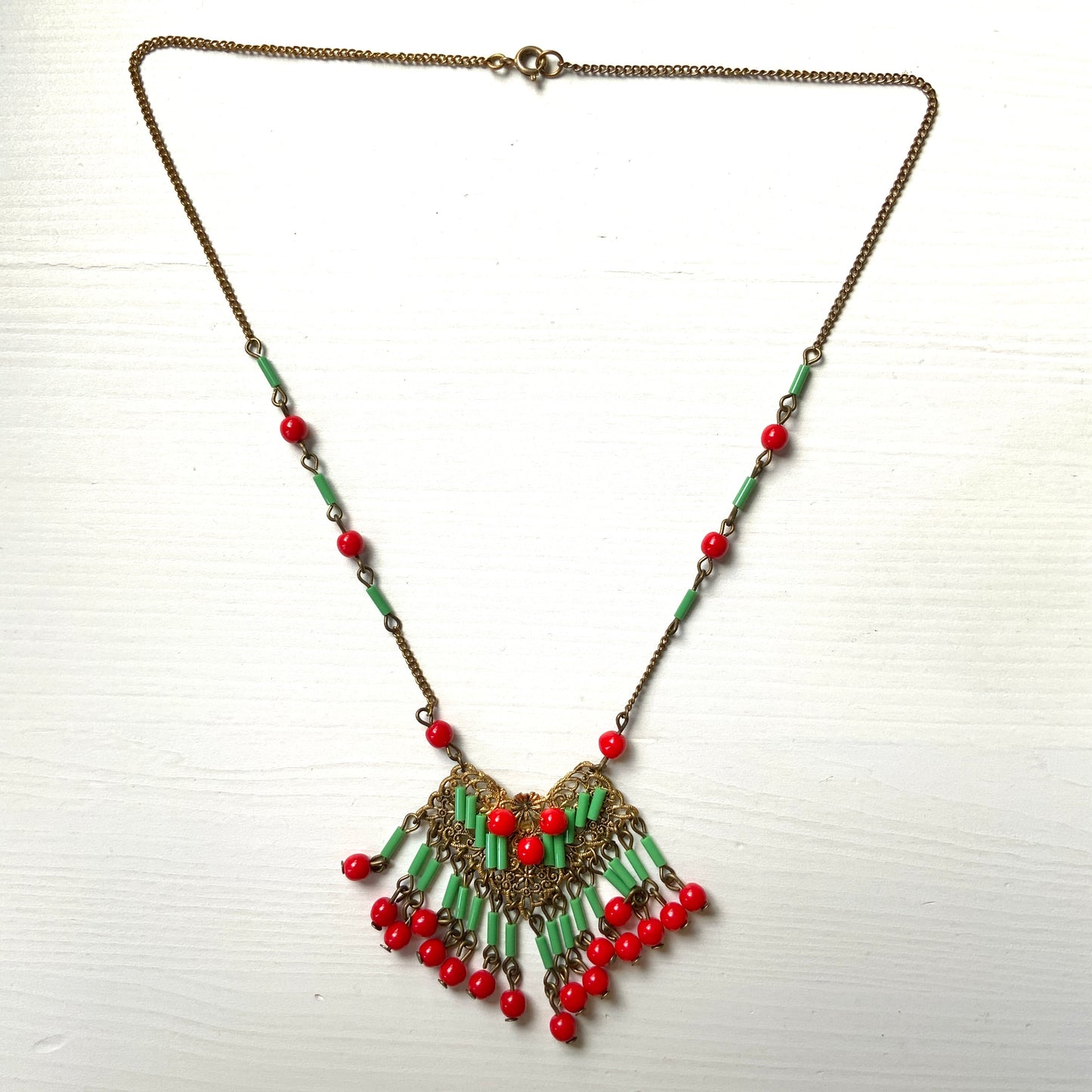 A necklace adorned with vivid red and yellow-green glass that sways with every movement. ヴィヴィッドなレッドとイエローグリーンのグラスがゆれるネックレス。