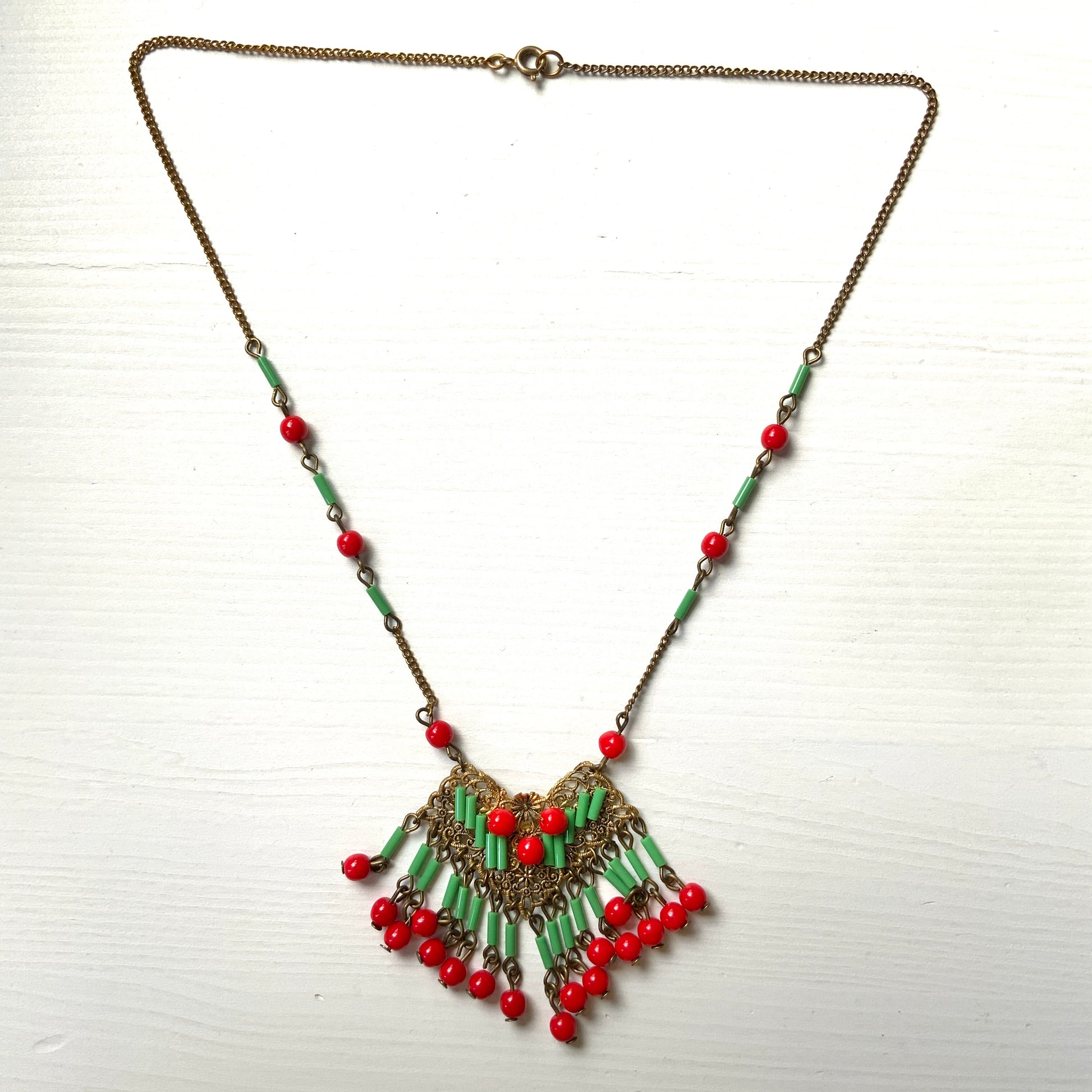A necklace adorned with vivid red and yellow-green glass that sways with every movement. ヴィヴィッドなレッドとイエローグリーンのグラスがゆれるネックレス。