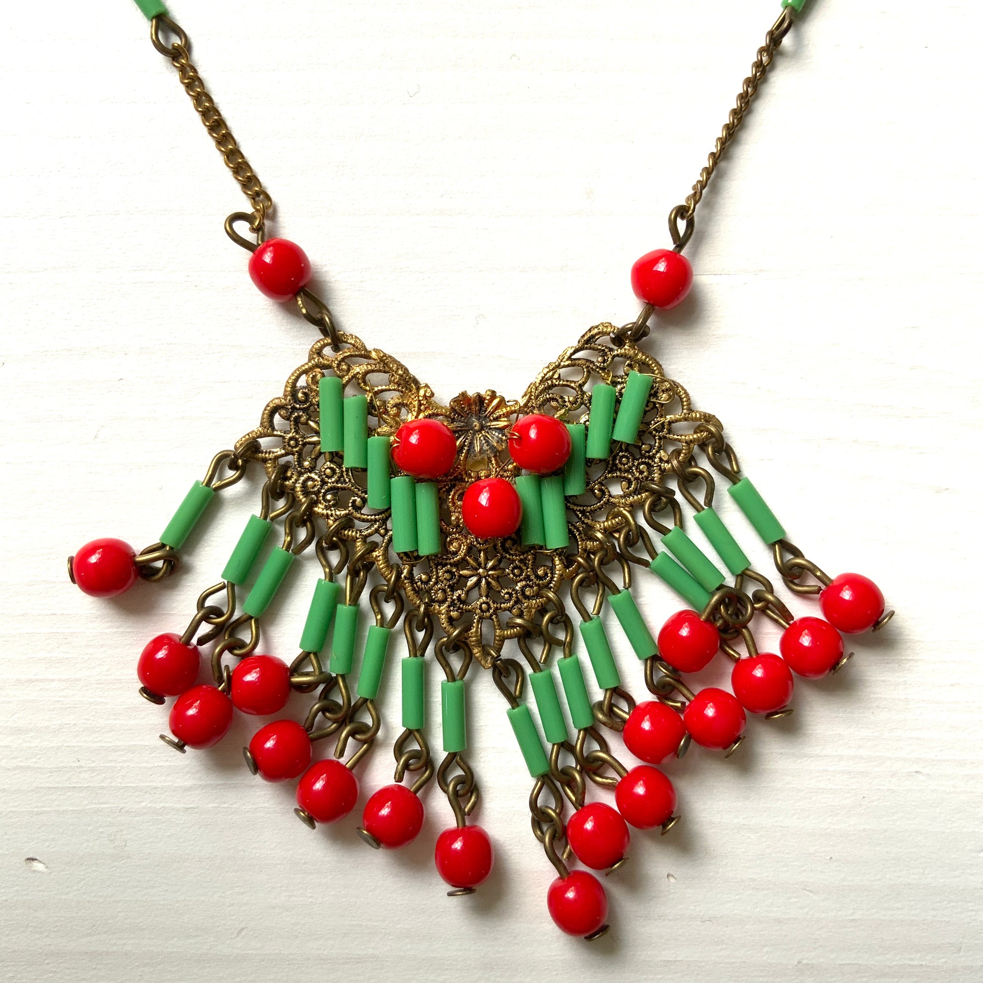 A necklace adorned with vivid red and yellow-green glass that sways with every movement. ヴィヴィッドなレッドとイエローグリーンのグラスがゆれるネックレス。