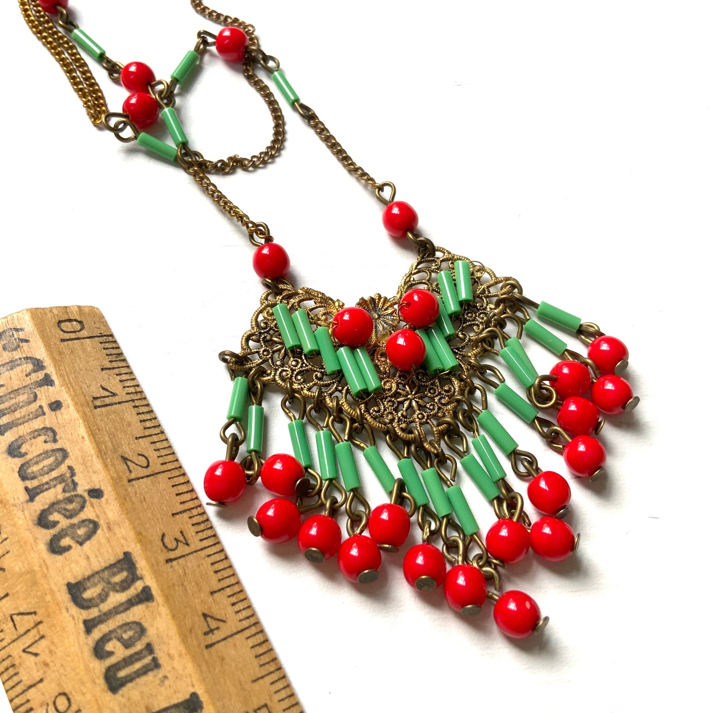A necklace adorned with vivid red and yellow-green glass that sways with every movement. ヴィヴィッドなレッドとイエローグリーンのグラスがゆれるネックレス。