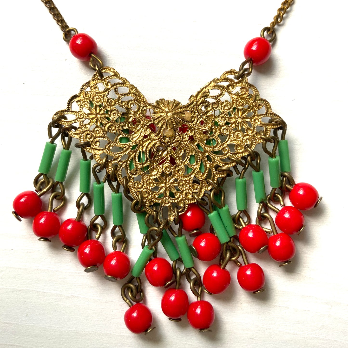 A necklace adorned with vivid red and yellow-green glass that sways with every movement. ヴィヴィッドなレッドとイエローグリーンのグラスがゆれるネックレス。