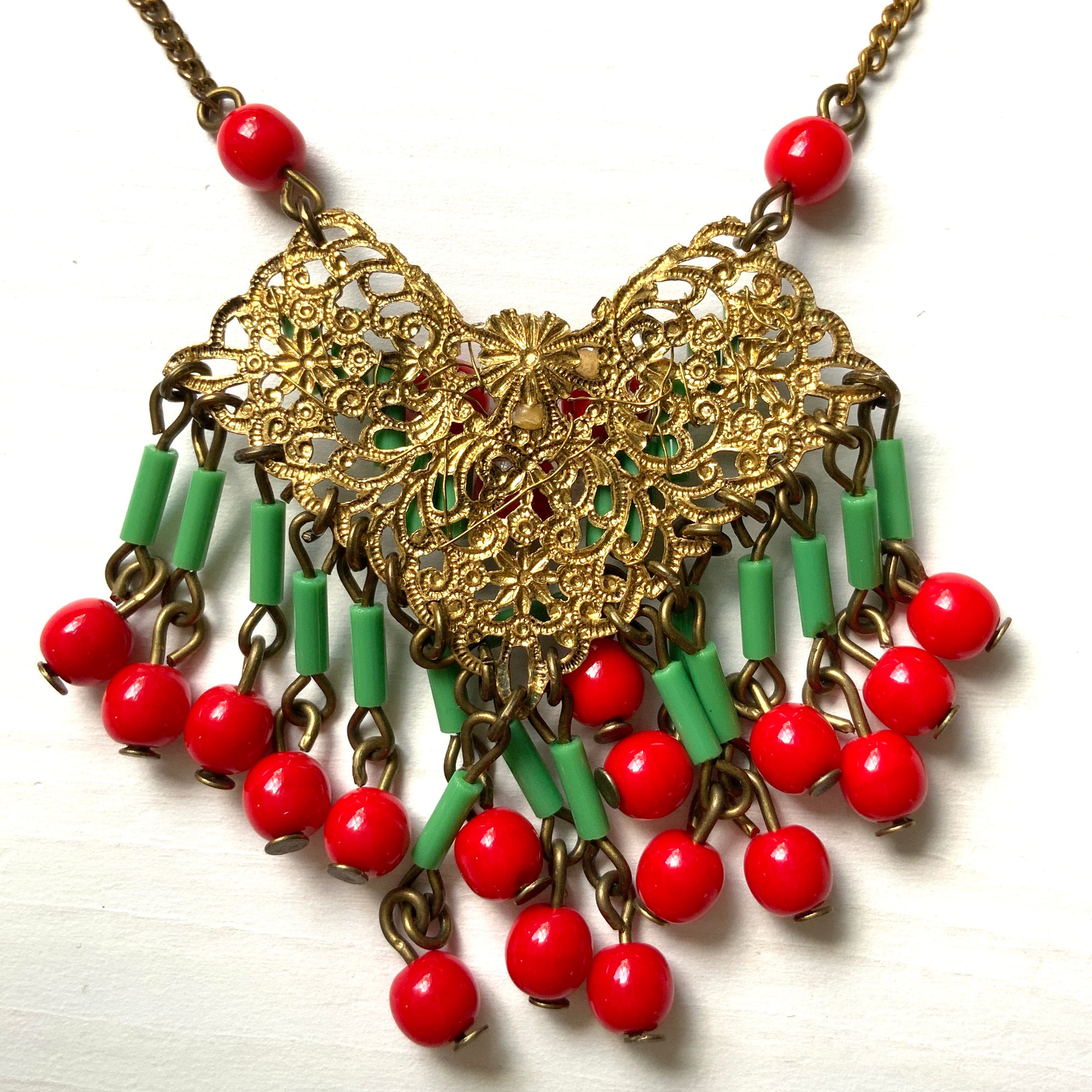 A necklace adorned with vivid red and yellow-green glass that sways with every movement. ヴィヴィッドなレッドとイエローグリーンのグラスがゆれるネックレス。
