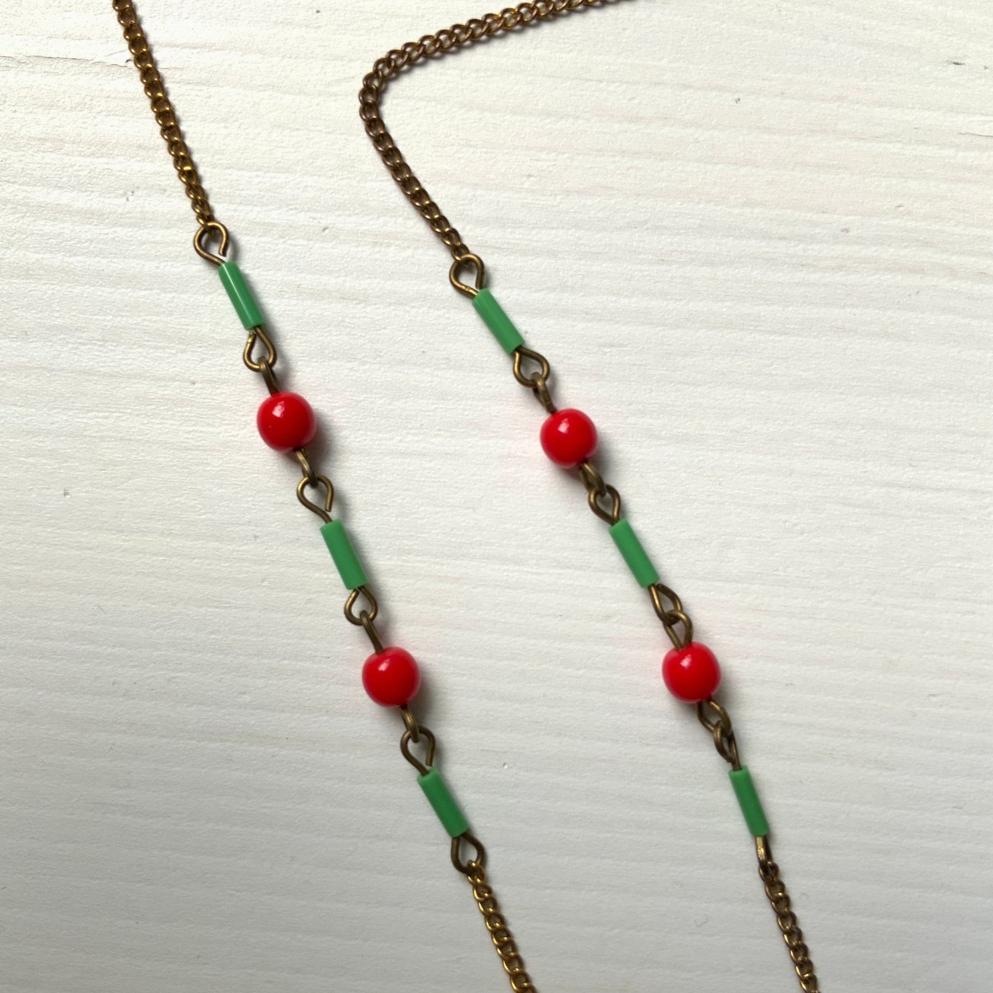 A necklace adorned with vivid red and yellow-green glass that sways with every movement. ヴィヴィッドなレッドとイエローグリーンのグラスがゆれるネックレス。
