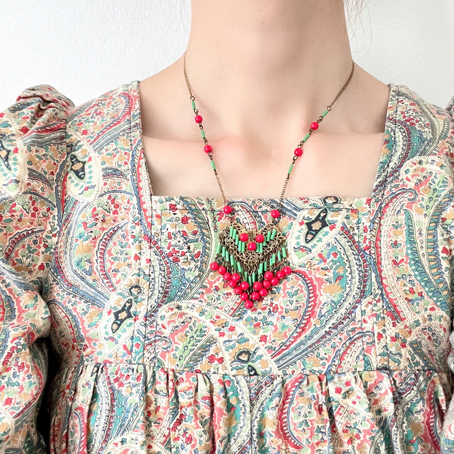 A necklace adorned with vivid red and yellow-green glass that sways with every movement. ヴィヴィッドなレッドとイエローグリーンのグラスがゆれるネックレス。