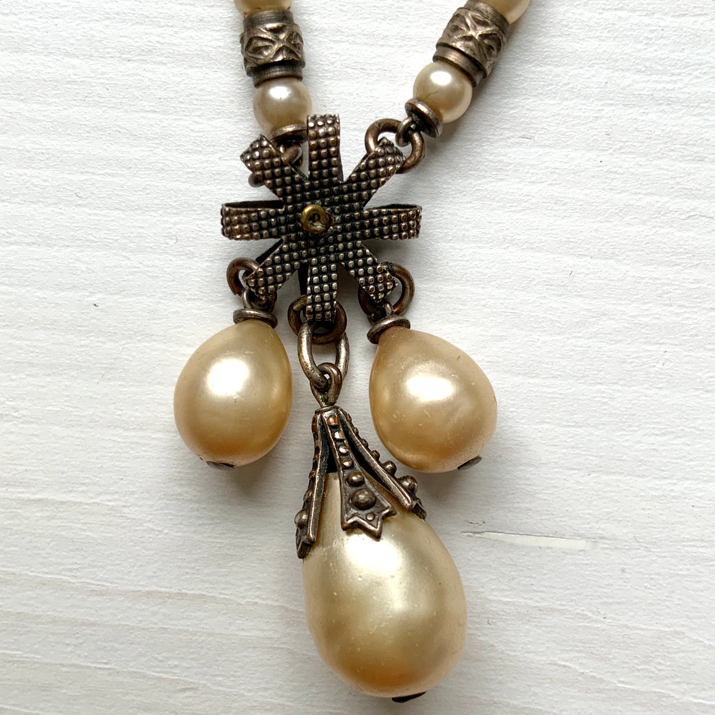 A necklace featuring metal flowers reminiscent of daisies, from which dangle chunky handmade teardrop glass pearls. デイジーのようなメタルのお花に、ゴロンとしたハンドメイドのティアドロップグラスパールがさがったネックレス。