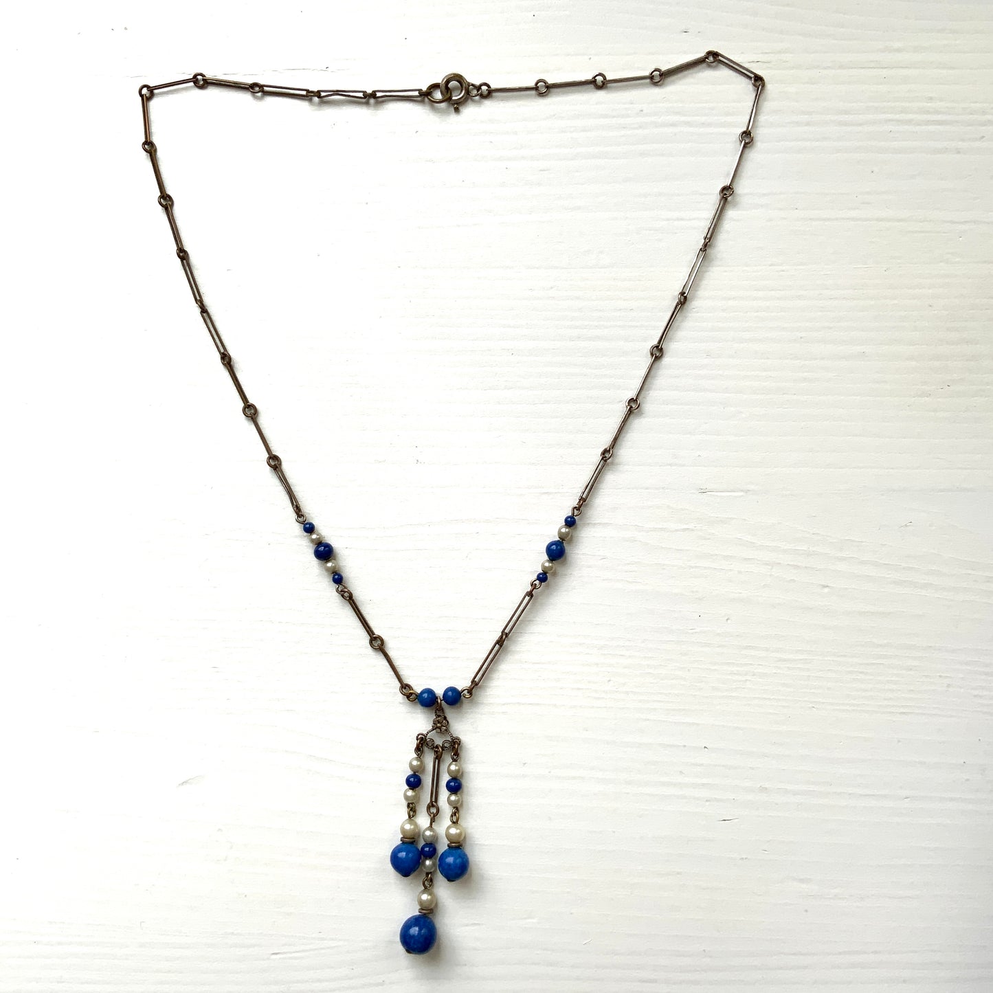 A fringe necklace featuring alternating small blue mottled glass beads and glass pearls. 小粒のブルー北京グラスとグラスパールが交互に連なってフリンジになったネックレス。