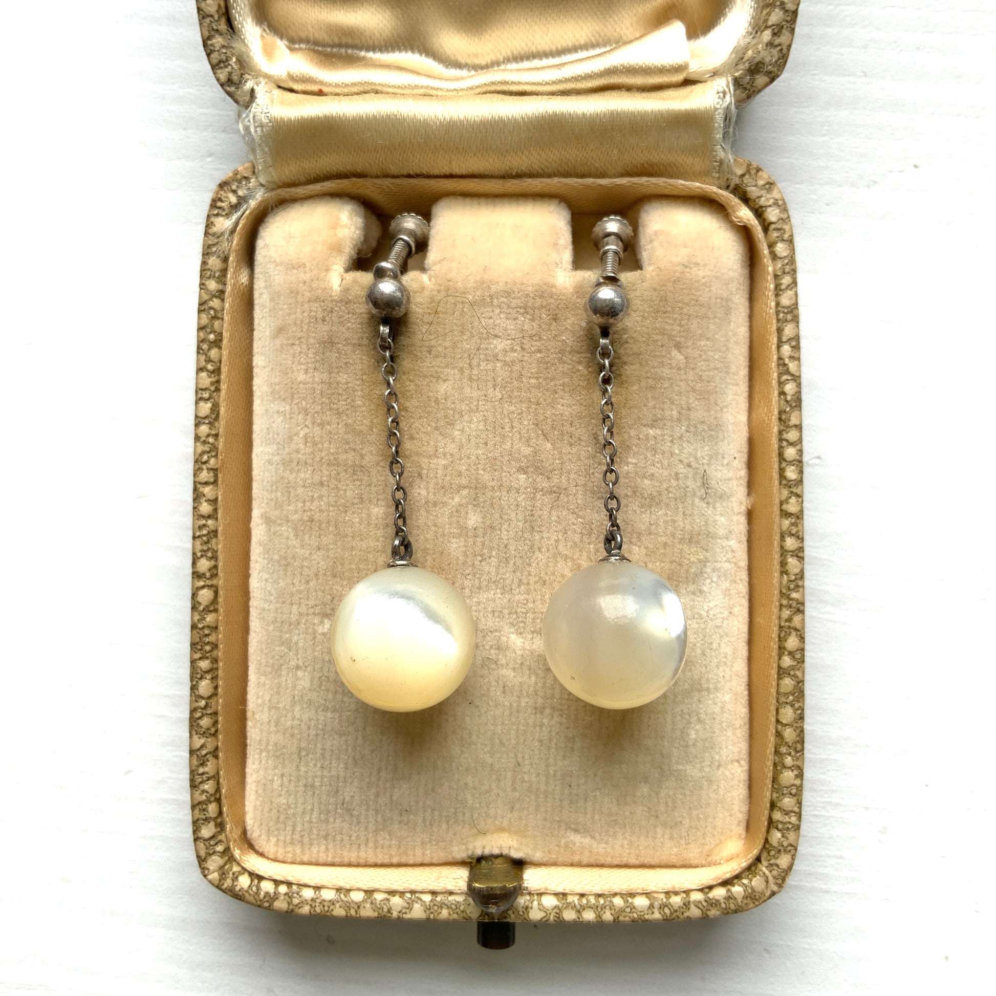 Silver screw-back earrings with dangling mother-of-pearl ball beads. マザーオブパールのボールビーズがゆれる、シルバーのスクリューバックイヤリング。