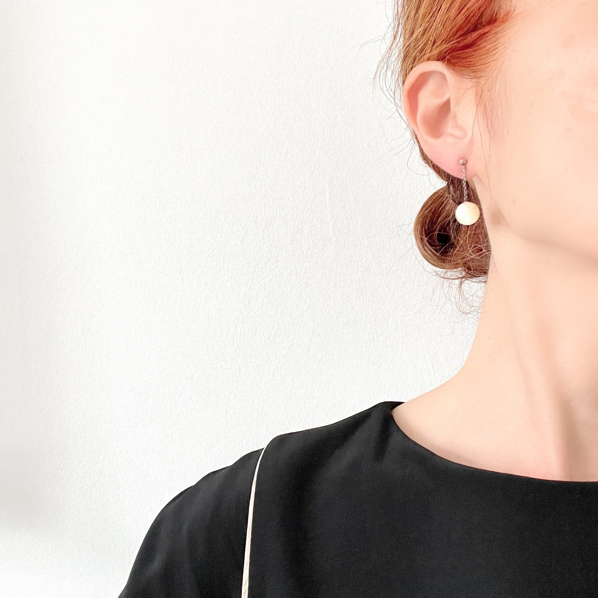 Silver screw-back earrings with dangling mother-of-pearl ball beads. マザーオブパールのボールビーズがゆれる、シルバーのスクリューバックイヤリング。