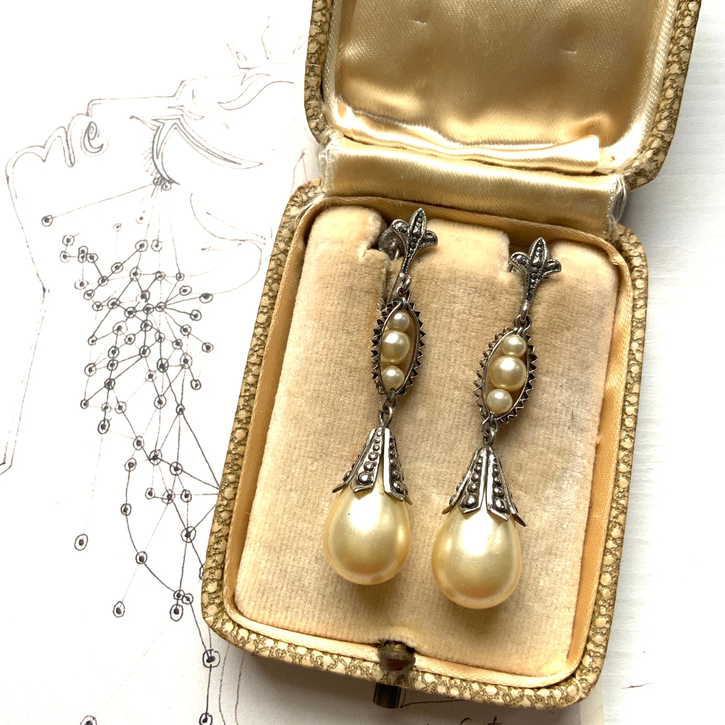 Screw-back earrings featuring teardrop glass pearls that gently dangle. ティアドロップのグラスパールが揺れるスクリューバックイヤリング。