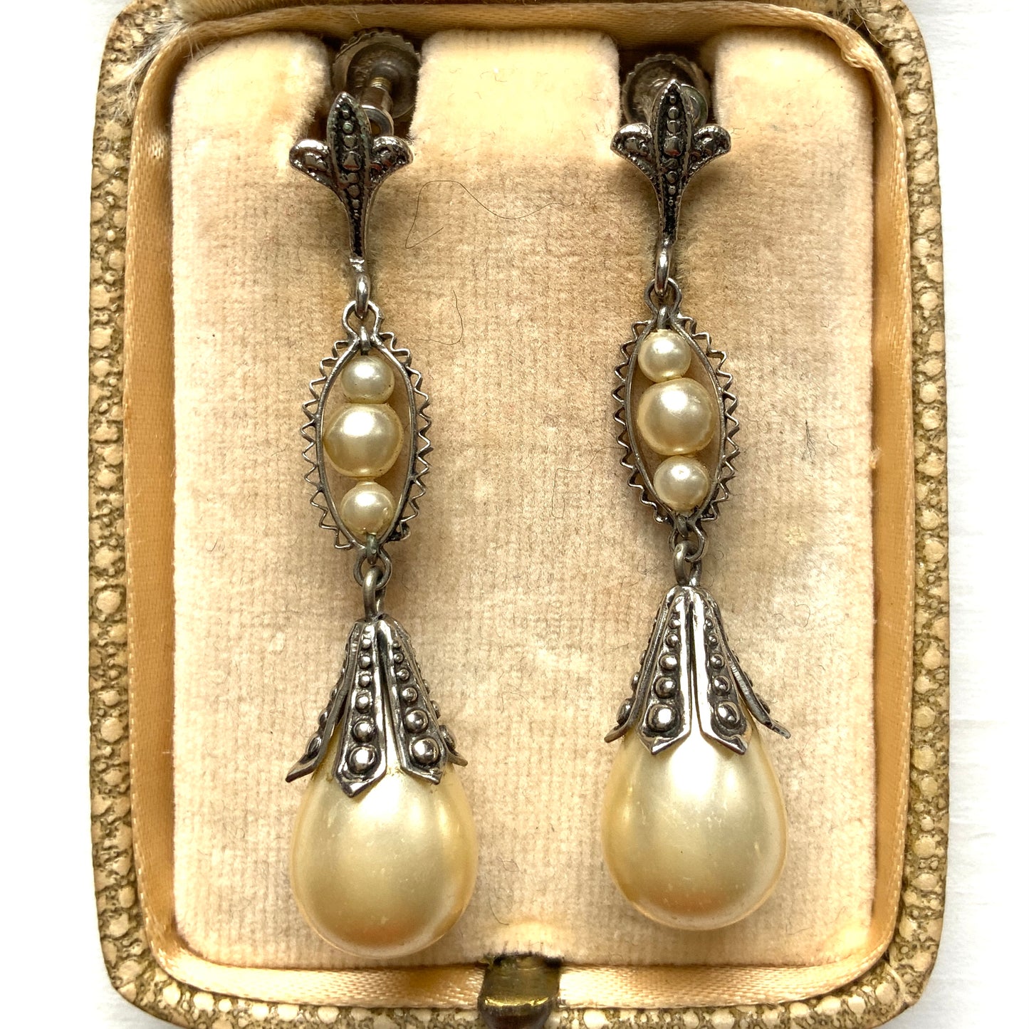 Screw-back earrings featuring teardrop glass pearls that gently dangle. ティアドロップのグラスパールが揺れるスクリューバックイヤリング。