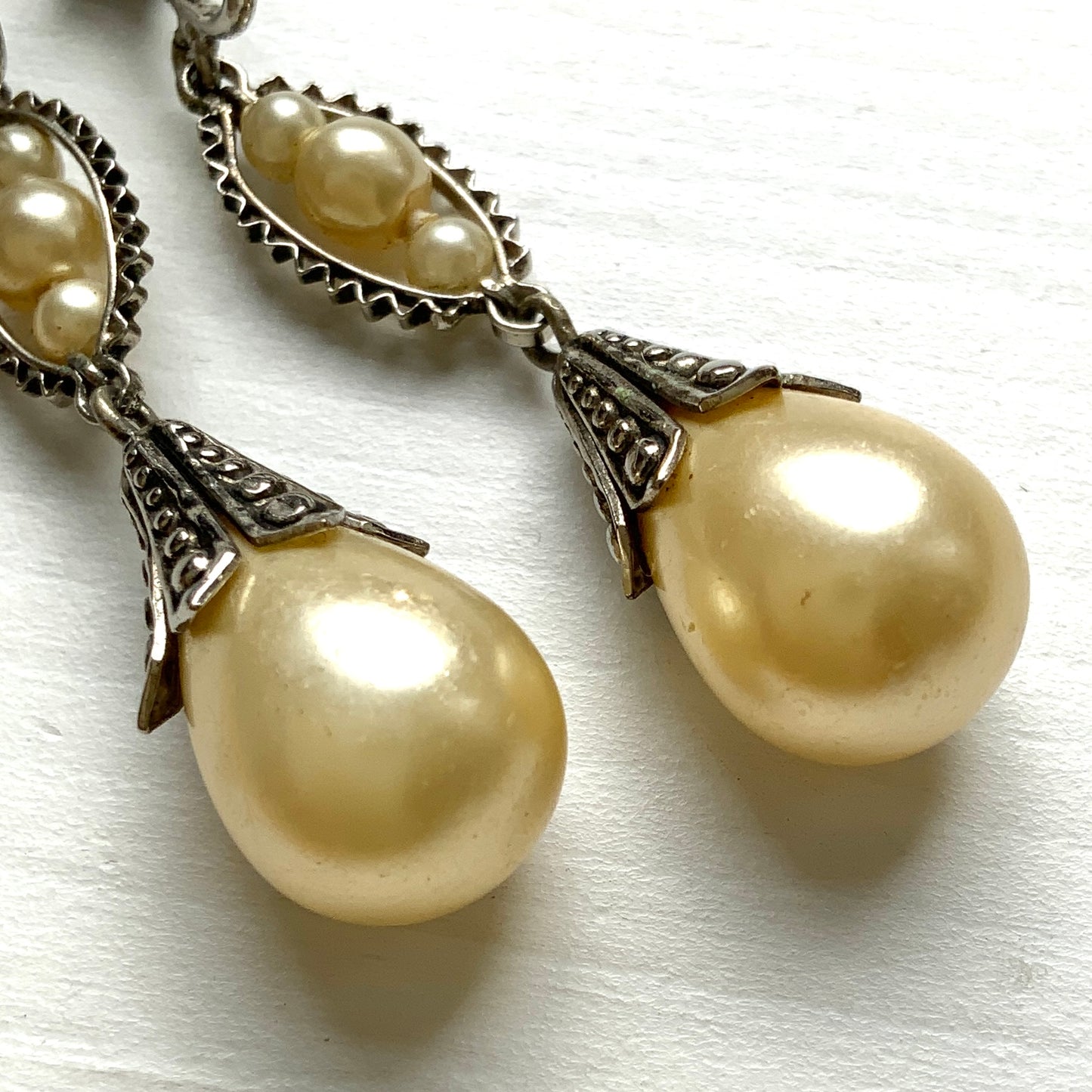 Screw-back earrings featuring teardrop glass pearls that gently dangle. ティアドロップのグラスパールが揺れるスクリューバックイヤリング。