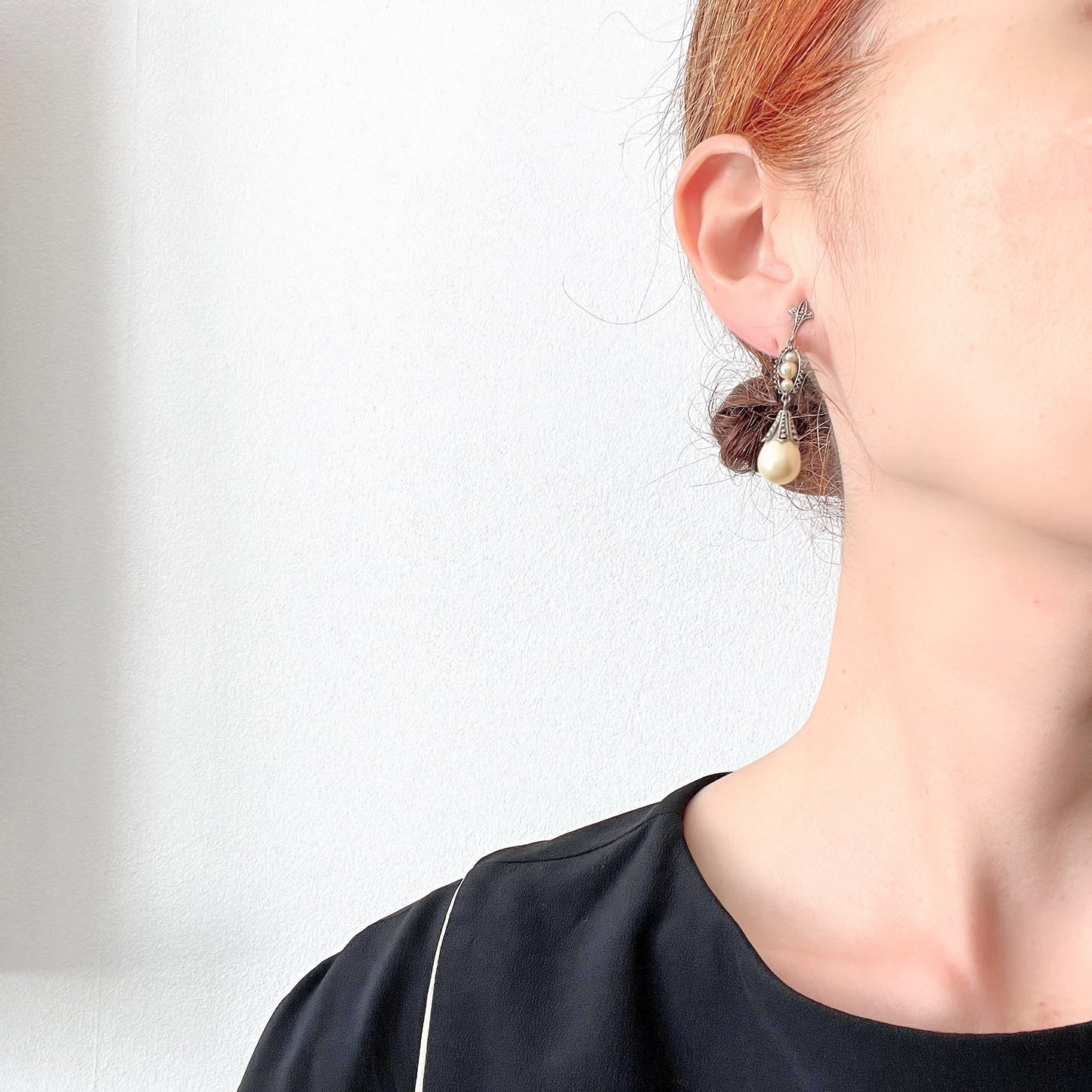 Screw-back earrings featuring teardrop glass pearls that gently dangle. ティアドロップのグラスパールが揺れるスクリューバックイヤリング。