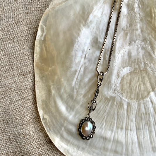 A lavallière-type necklace featuring an oval pearl shining in silvery white and marcasite. 白銀に輝くオーバル パールとマーカサイトのラヴァリエタイプのネックレス。