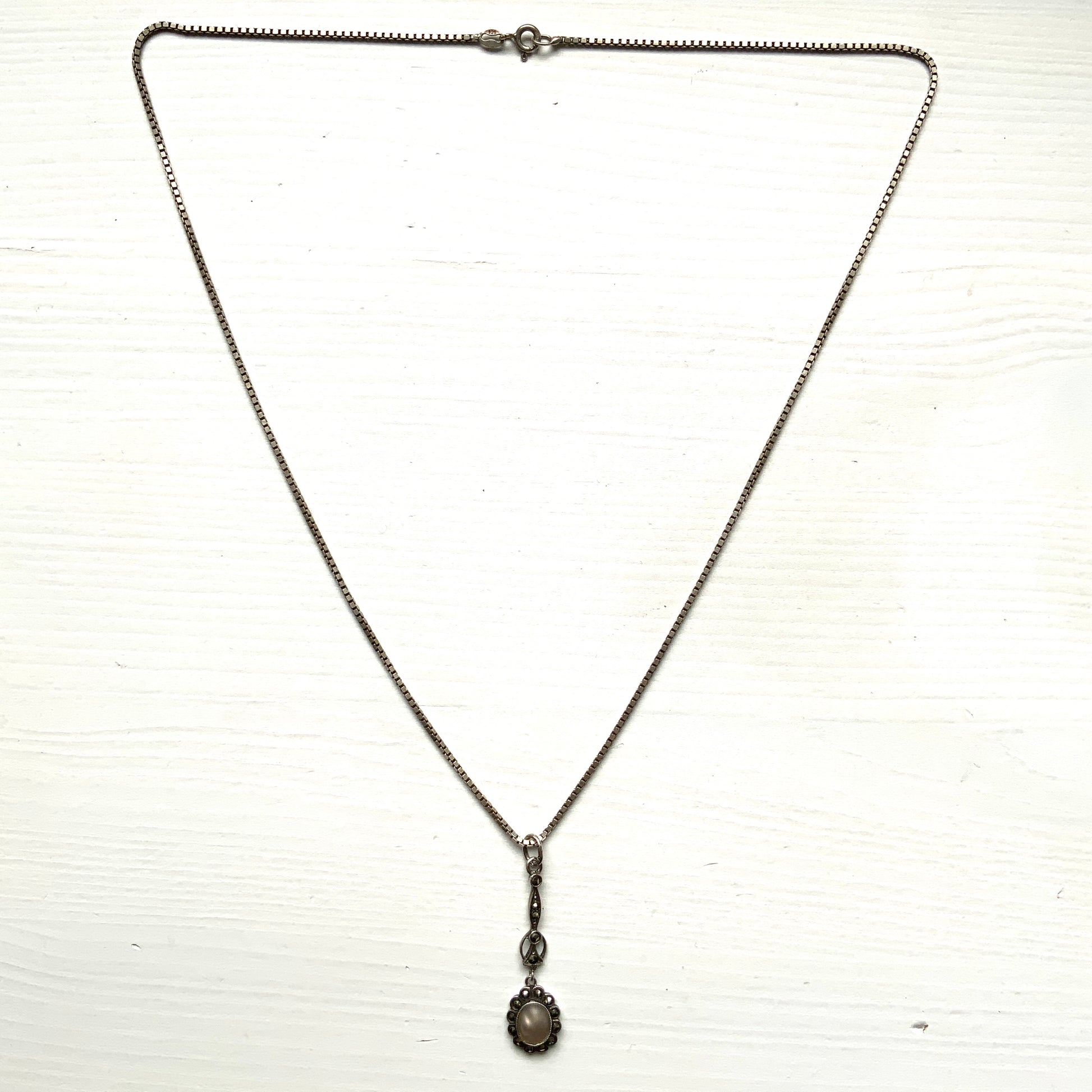 A lavallière-type necklace featuring an oval pearl shining in silvery white and marcasite. 白銀に輝くオーバル パールとマーカサイトのラヴァリエタイプのネックレス。