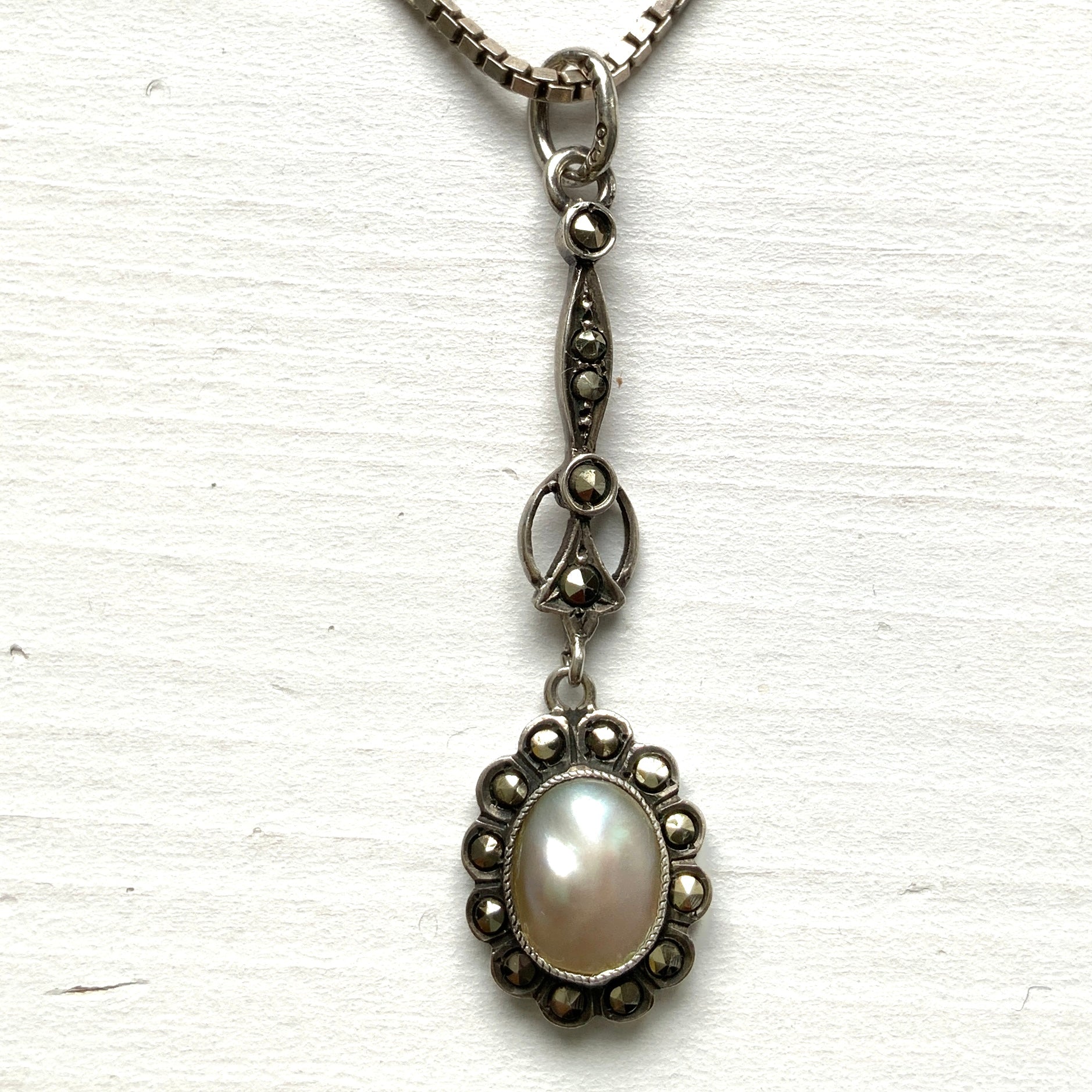 A lavallière-type necklace featuring an oval pearl shining in silvery white and marcasite. 白銀に輝くオーバル パールとマーカサイトのラヴァリエタイプのネックレス。