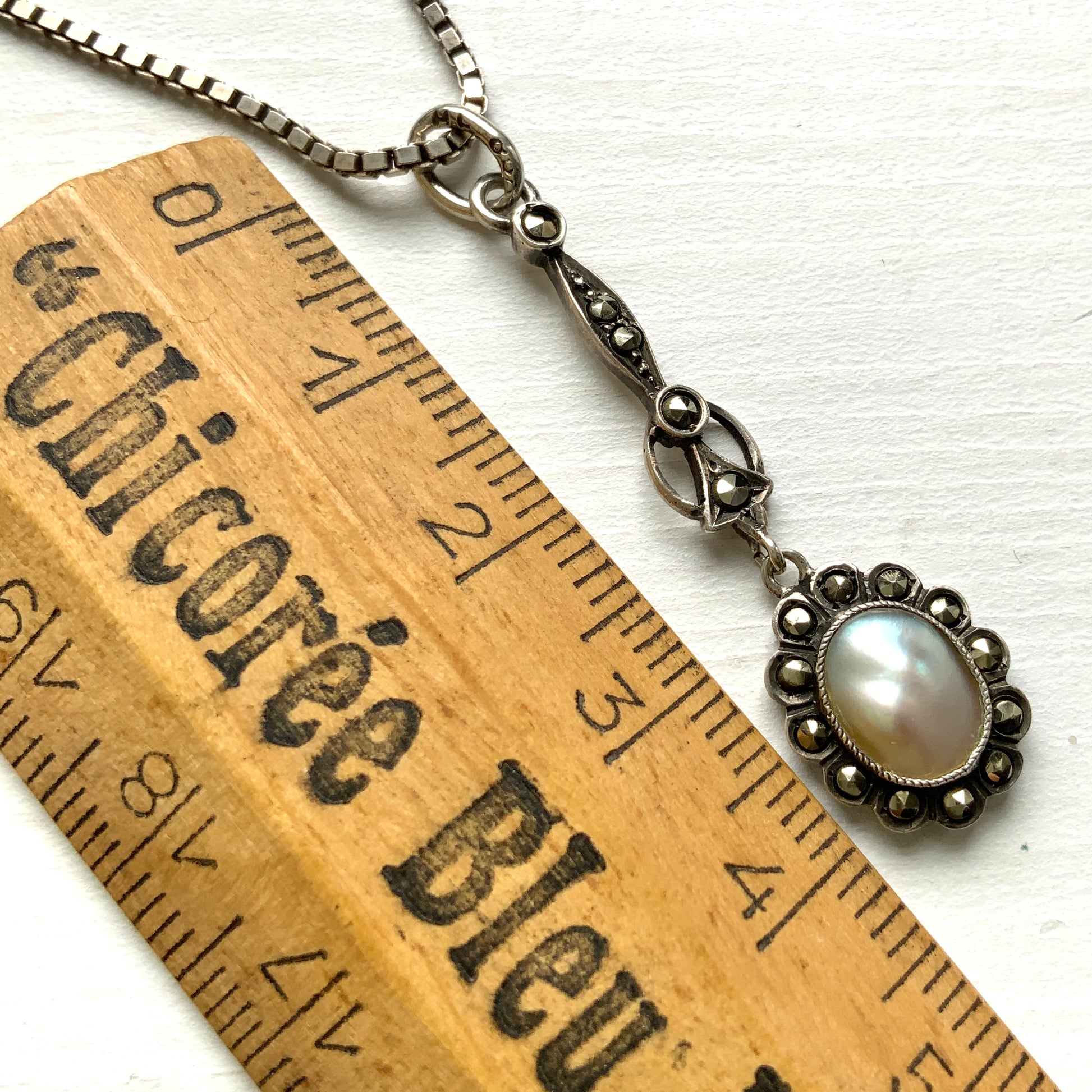 A lavallière-type necklace featuring an oval pearl shining in silvery white and marcasite. 白銀に輝くオーバル パールとマーカサイトのラヴァリエタイプのネックレス。