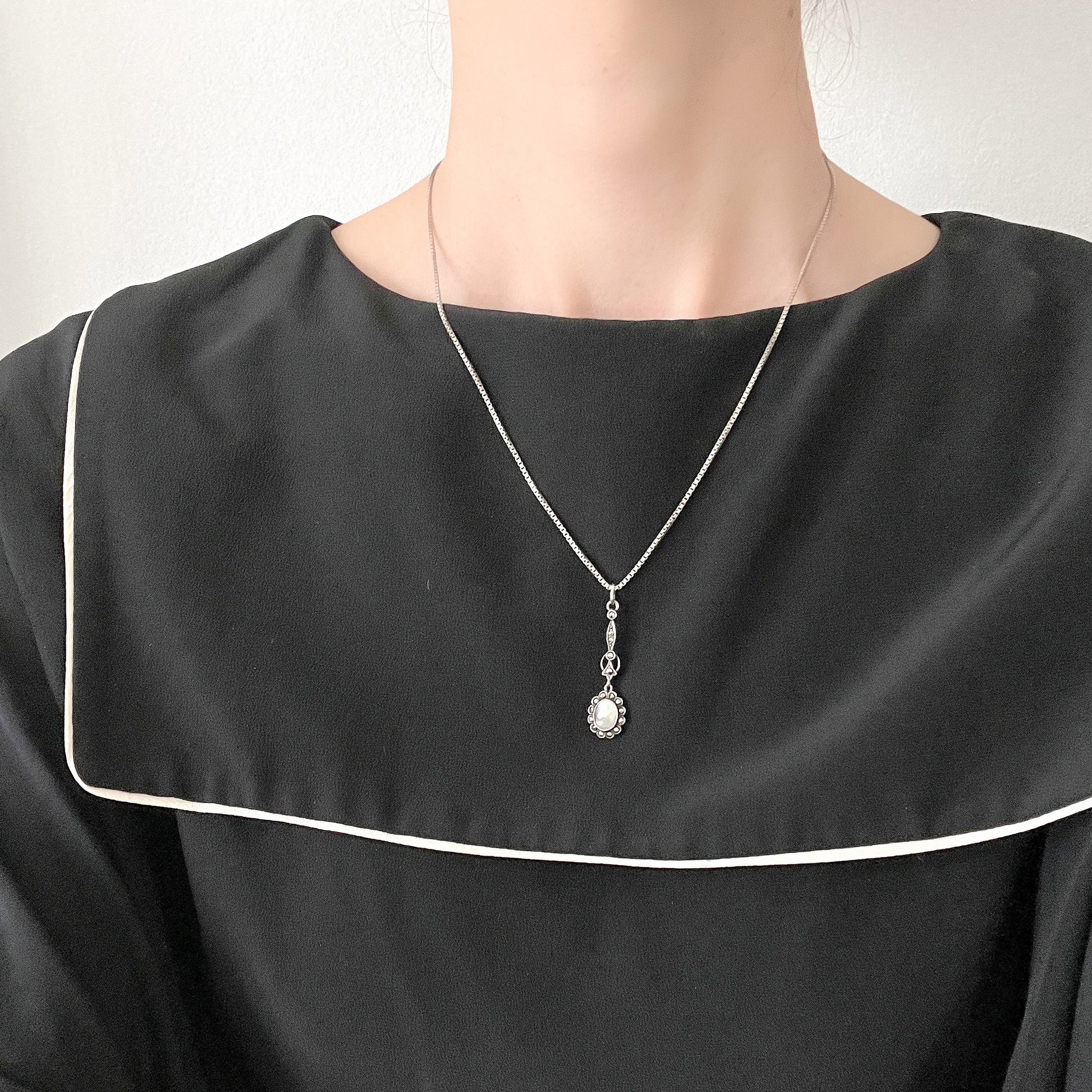 A lavallière-type necklace featuring an oval pearl shining in silvery white and marcasite. 白銀に輝くオーバル パールとマーカサイトのラヴァリエタイプのネックレス。