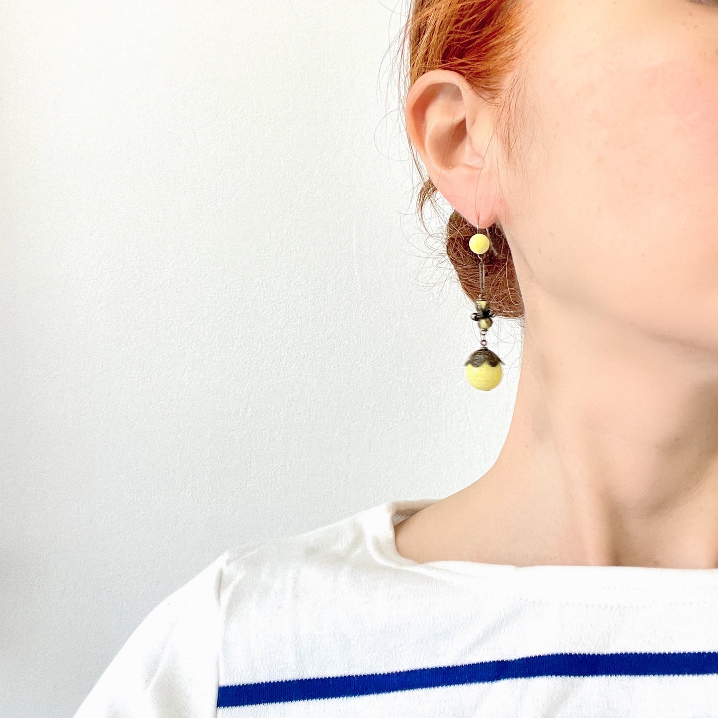 Uranium glass earrings featuring vibrant neon yellow glass beads with unique mottled patterns. 鮮やかなネオンイエローのウランガラスを使用したピアス。