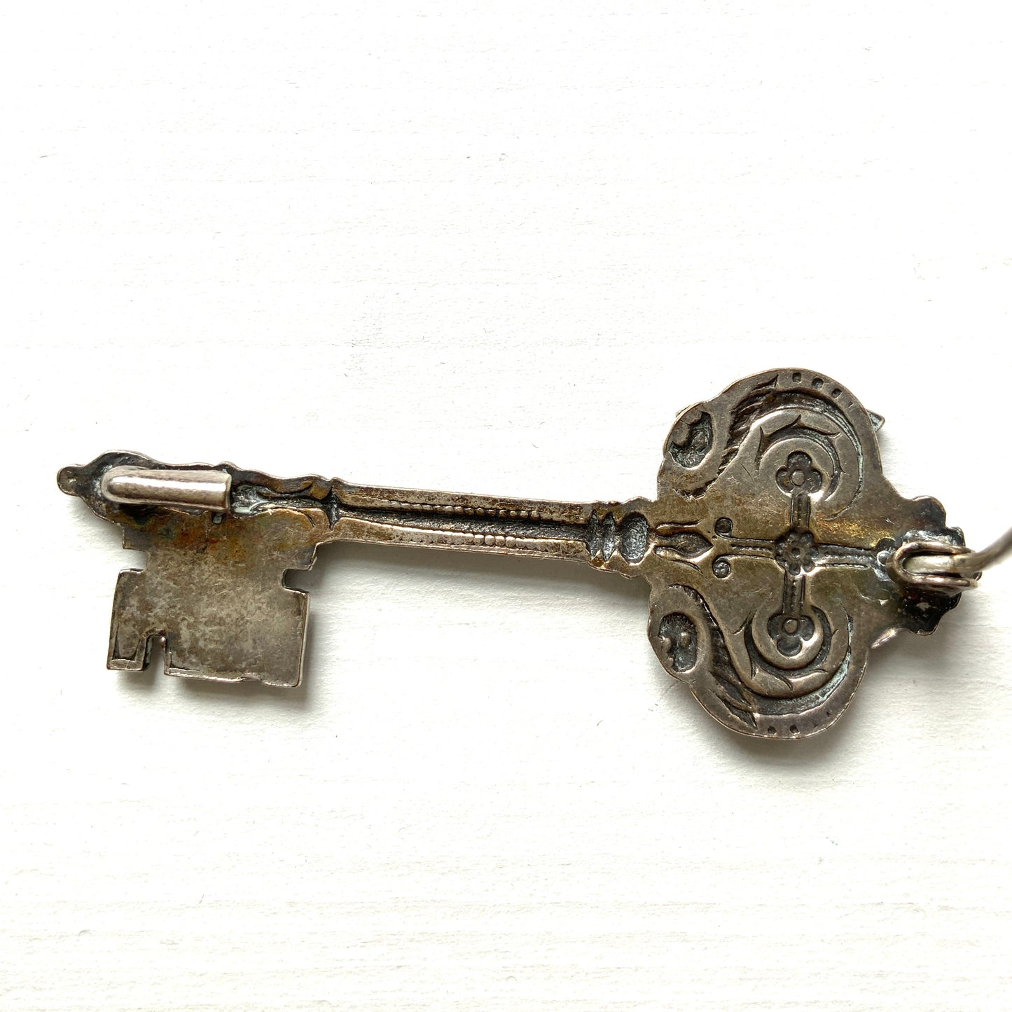 A decorative vintage key brooch featuring a crown and crest motif in a beautifully classical design. 王冠と紋章のモチーフ、クラシカルでデコラティブなデザインが素敵な鍵ブローチ。