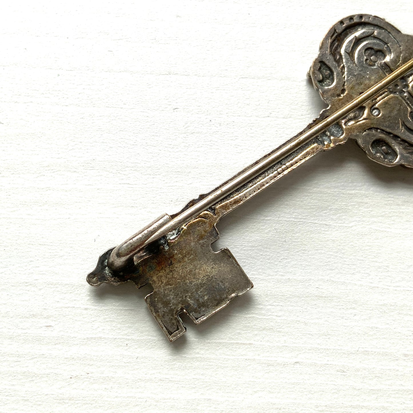 A decorative vintage key brooch featuring a crown and crest motif in a beautifully classical design. 王冠と紋章のモチーフ、クラシカルでデコラティブなデザインが素敵な鍵ブローチ。