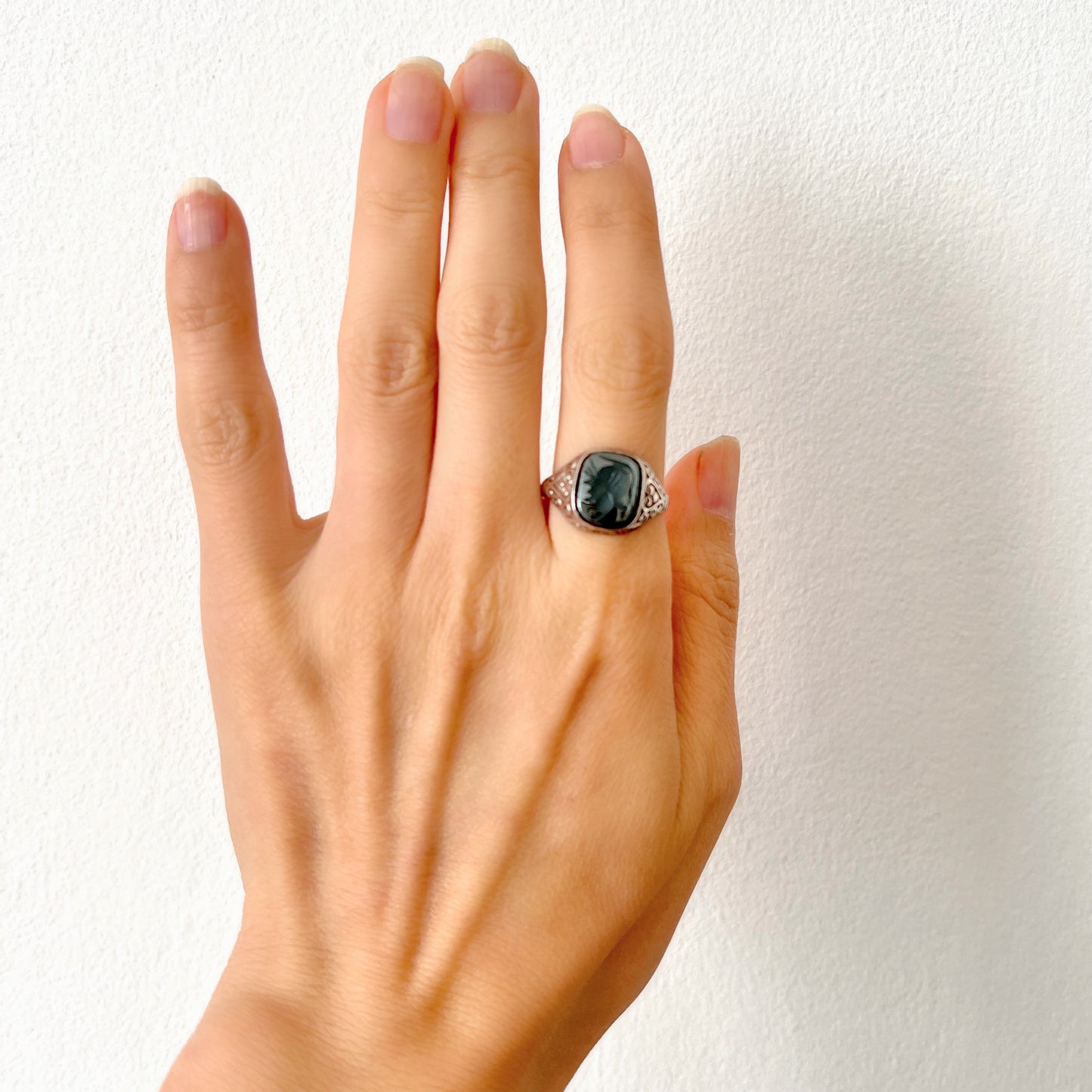 A silver ring set with dark grey, metallic hematite, intaglio-carved with the figure of a Roman warrior. ダークグレーのメタリックなヘマタイトに、ローマ時代の戦士と思われる人物像が沈み彫りされたシルバーリング。