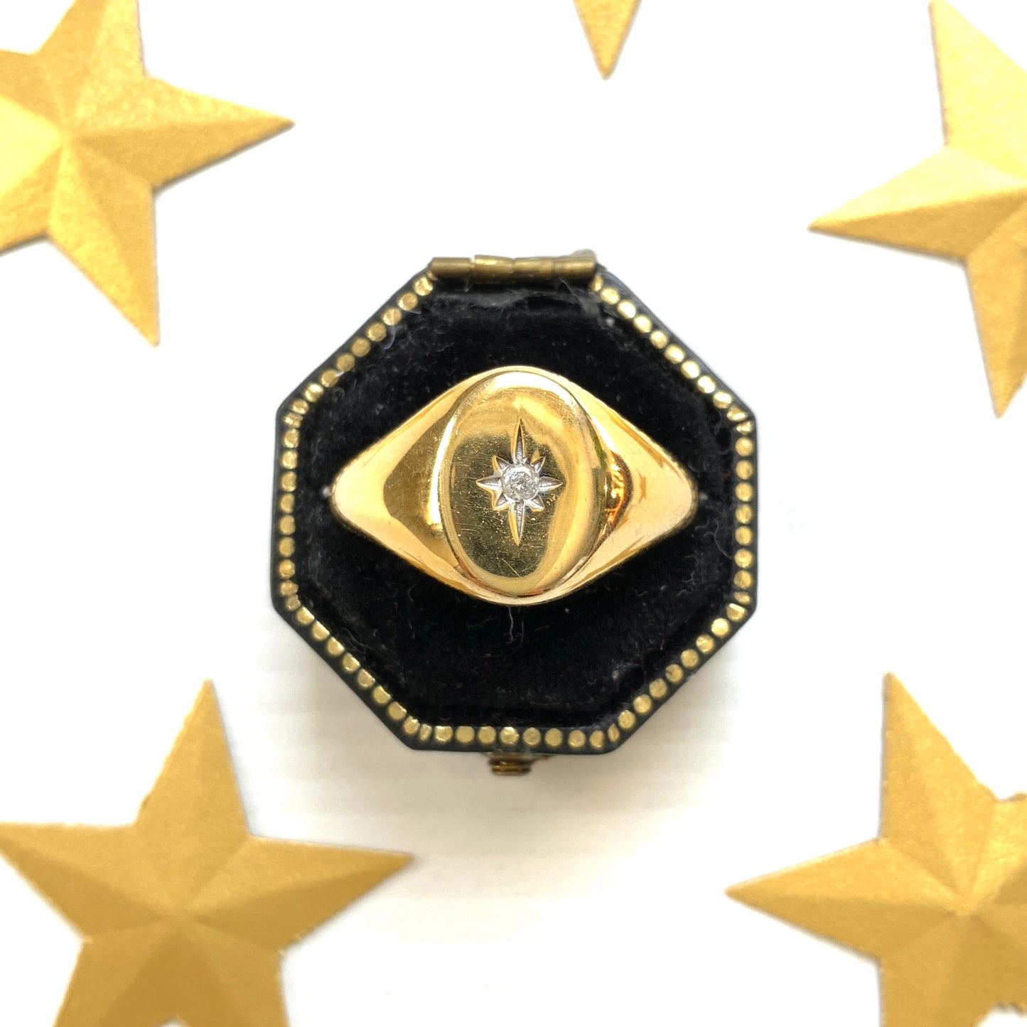 A gold-plated silver ring featuring an oval signet with a single clear stone sparkling at the centre. 楕円のシグネットにクリアストーンが一粒きらりと輝く金メッキされたシルバーリング。