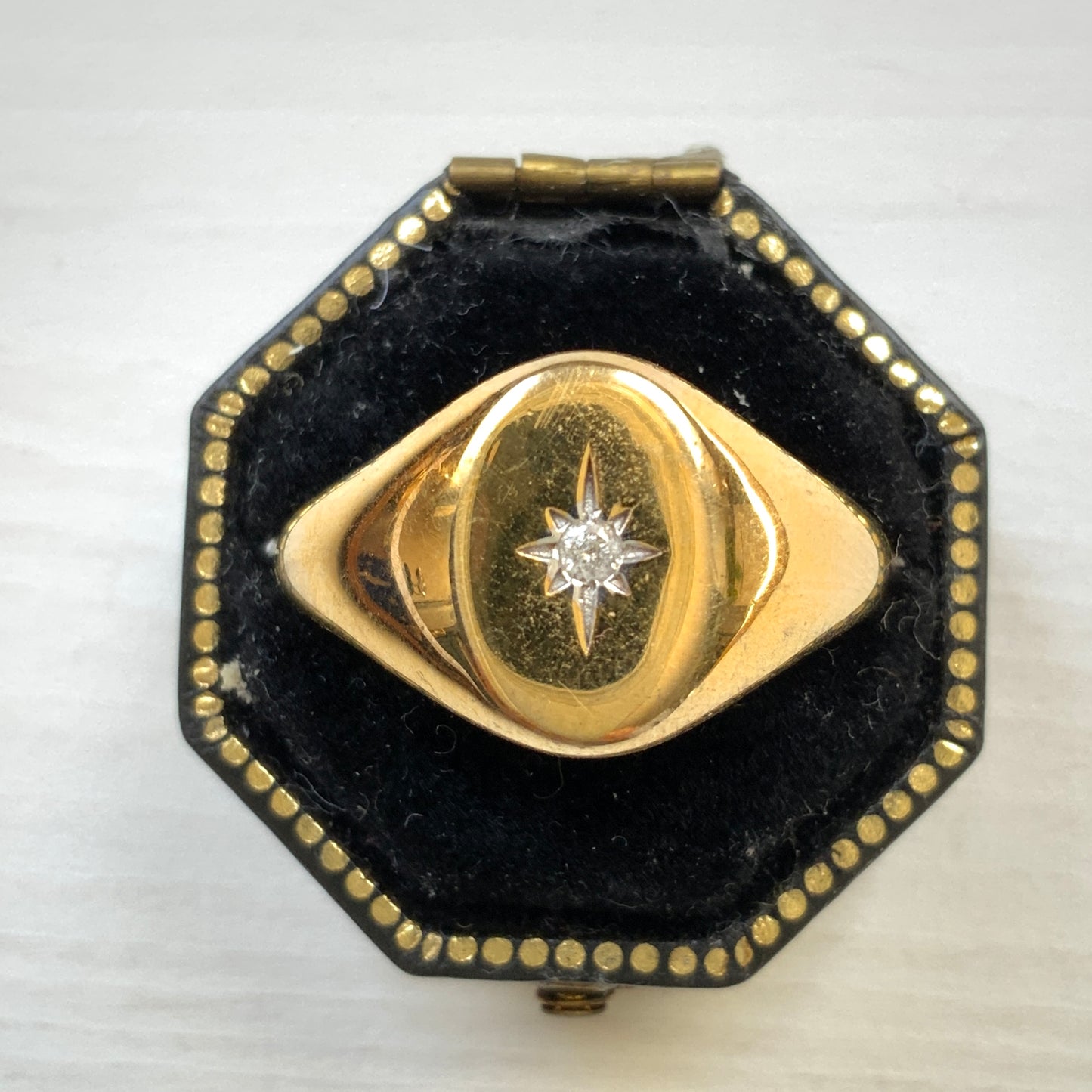 A gold-plated silver ring featuring an oval signet with a single clear stone sparkling at the centre. 楕円のシグネットにクリアストーンが一粒きらりと輝く金メッキされたシルバーリング。