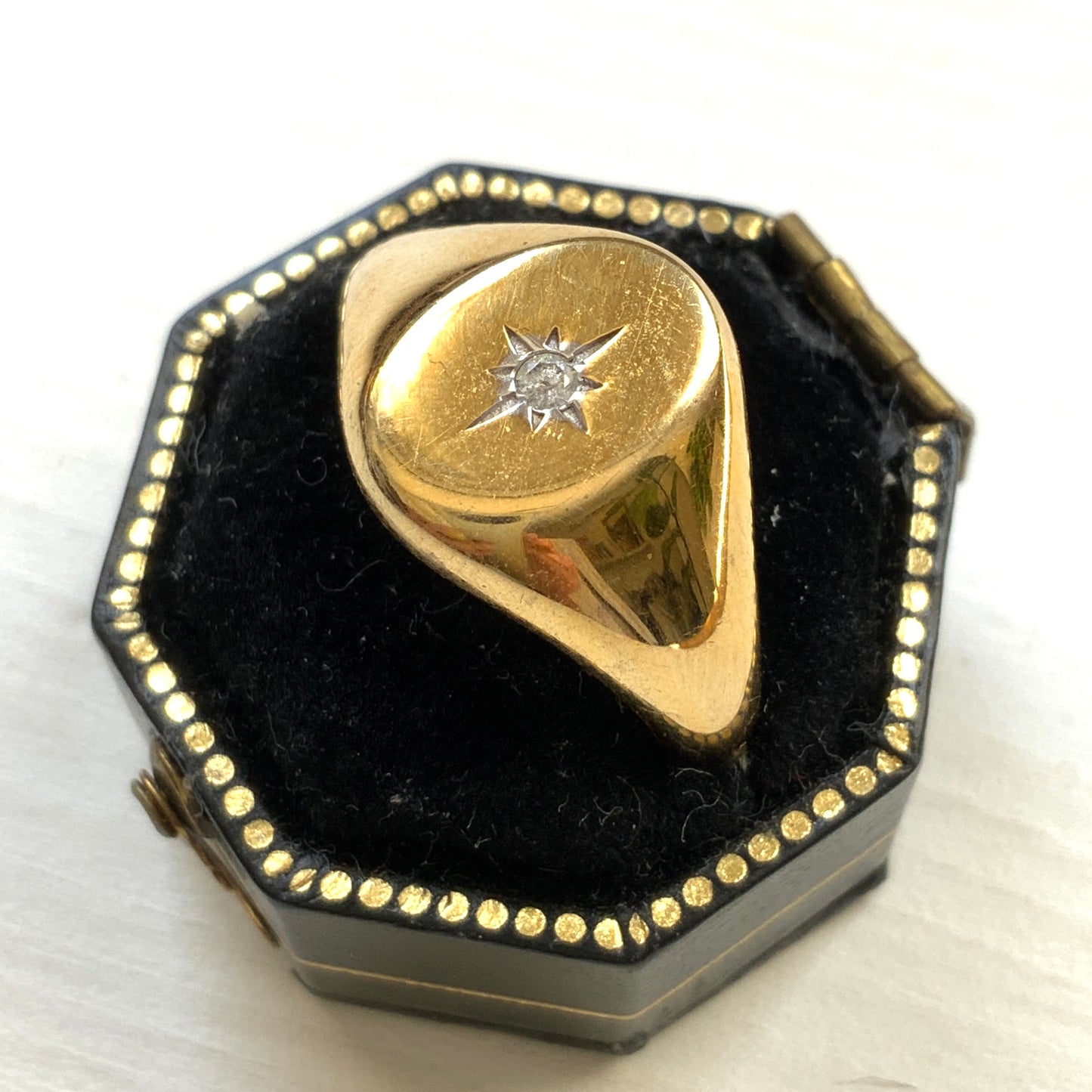 A gold-plated silver ring featuring an oval signet with a single clear stone sparkling at the centre. 楕円のシグネットにクリアストーンが一粒きらりと輝く金メッキされたシルバーリング。