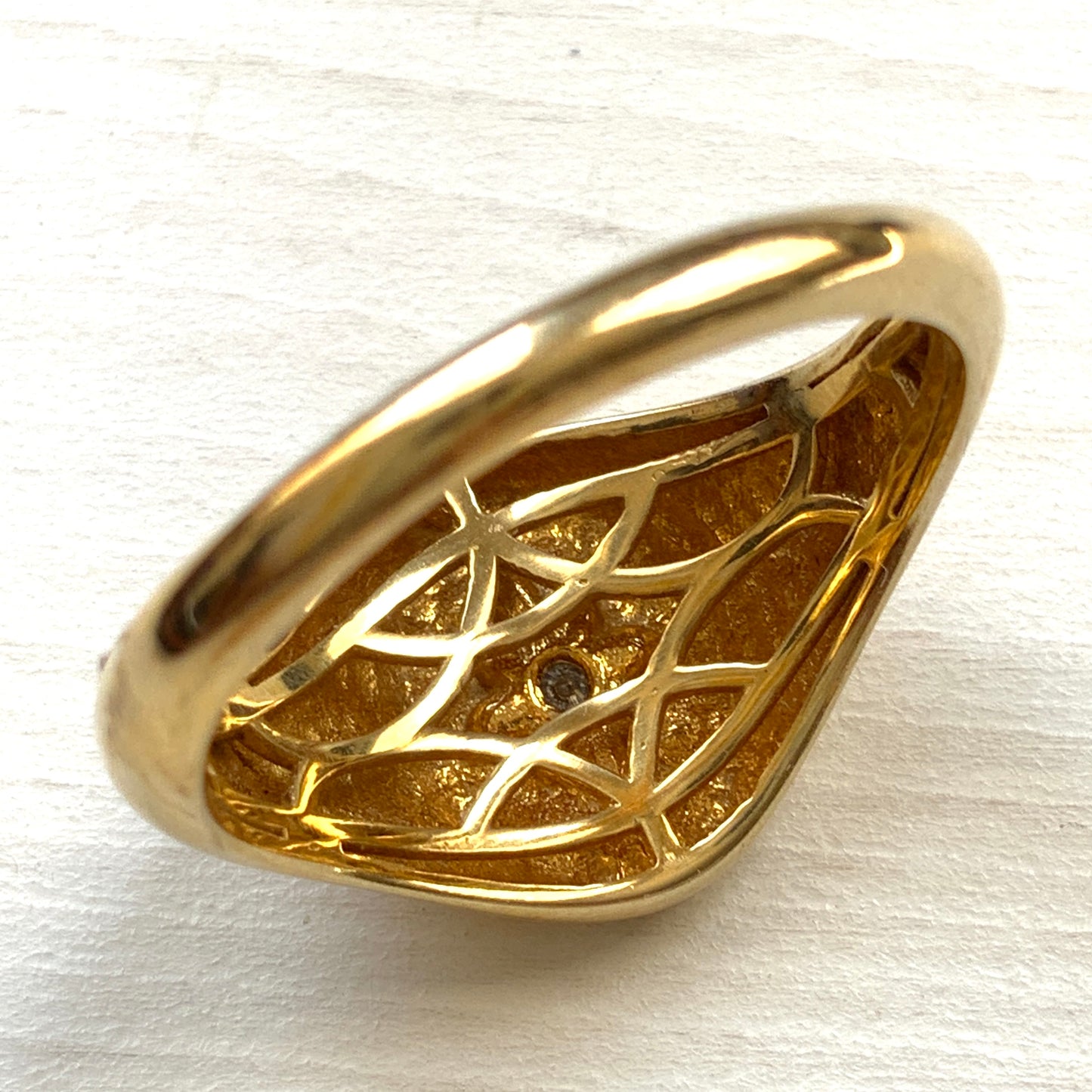 A gold-plated silver ring featuring an oval signet with a single clear stone sparkling at the centre. 楕円のシグネットにクリアストーンが一粒きらりと輝く金メッキされたシルバーリング。
