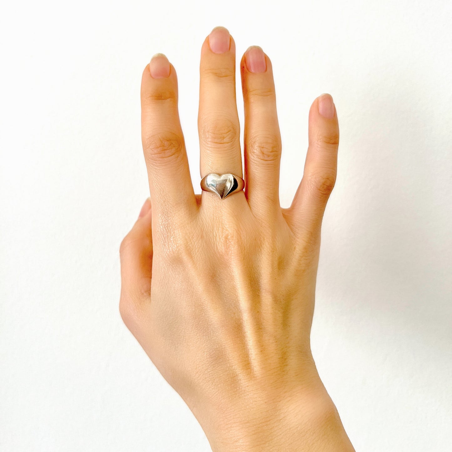 A silver ring shaped into a heart motif with smooth, flowing curves. 滑らかな曲線でハートモチーフに仕立てられたシルバーリング。