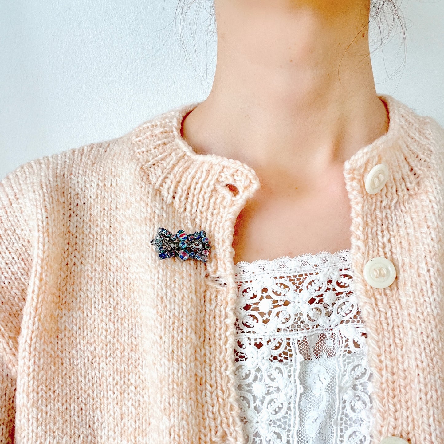 Vintage bow-shaped brooch set with iris glass stones. アイリスグラスがあしらわれた、リボンシェイプのブローチ。