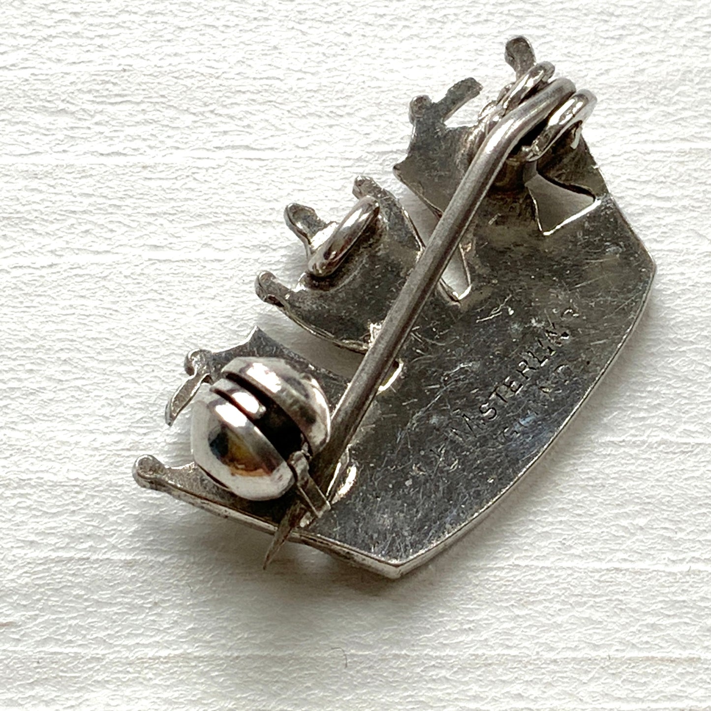 A silver brooch featuring a naval crown decorated with marcasite. マーカサイトがあしらわれた海軍王冠のシルバーのブローチ。