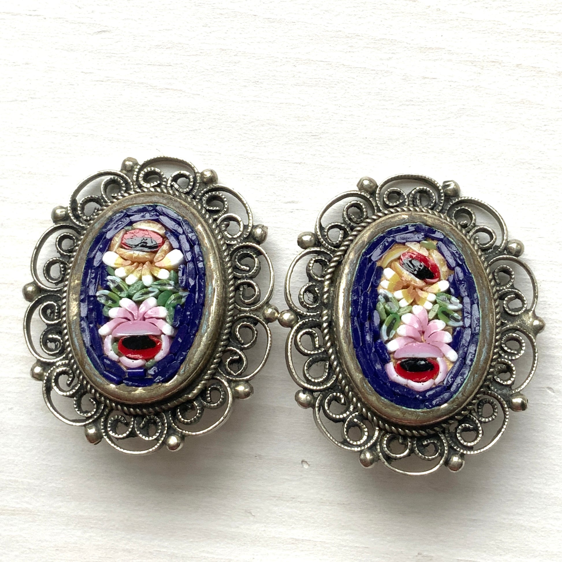These clip-on earrings feature a beautifully detailed micro mosaic framed with silver-tone filigree that resembles delicate lace. シルバートーン のフィリグリーがまるでレースのように縁にあしらわれたマイクロモザイク のクリップイヤリング。