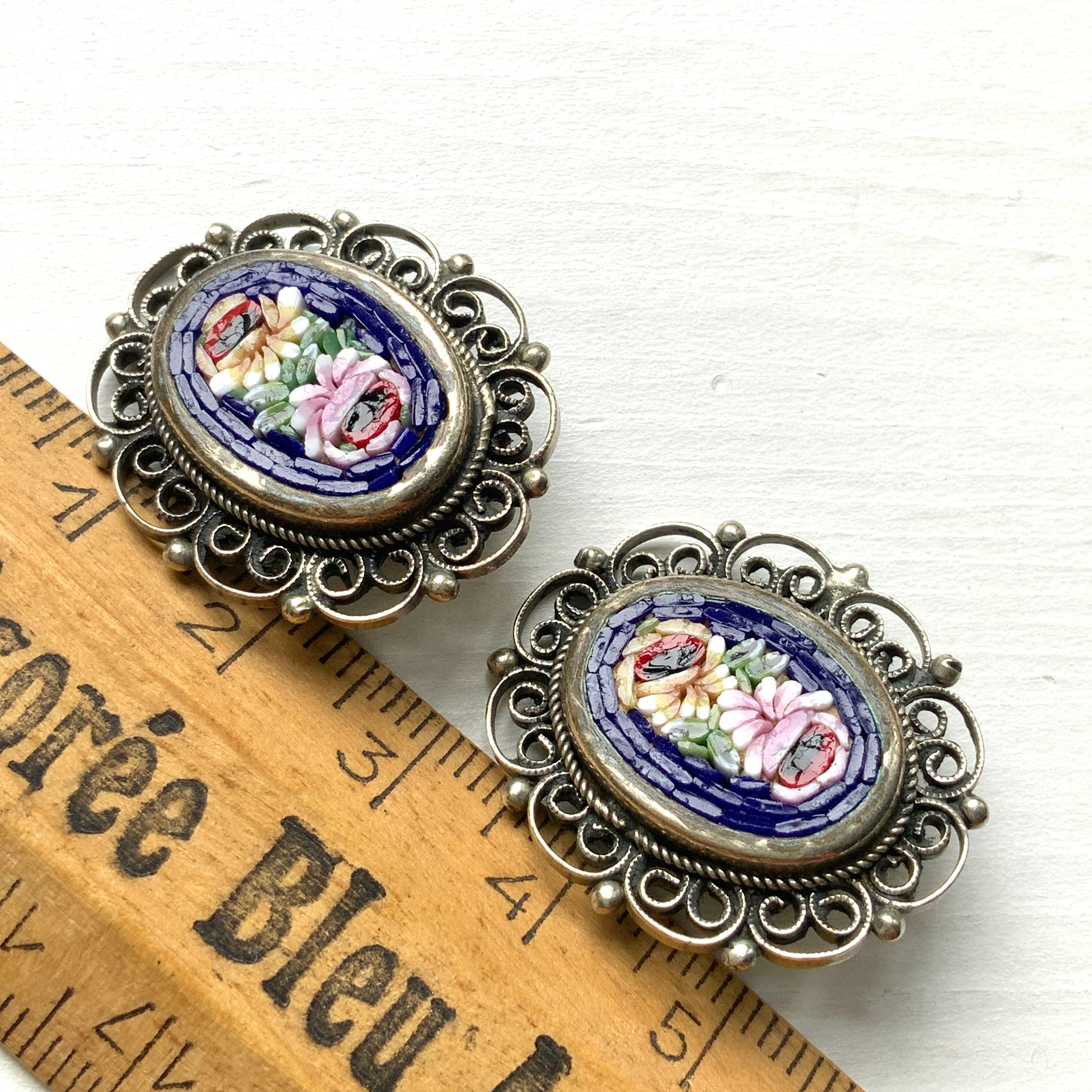 These clip-on earrings feature a beautifully detailed micro mosaic framed with silver-tone filigree that resembles delicate lace. シルバートーン のフィリグリーがまるでレースのように縁にあしらわれたマイクロモザイク のクリップイヤリング。