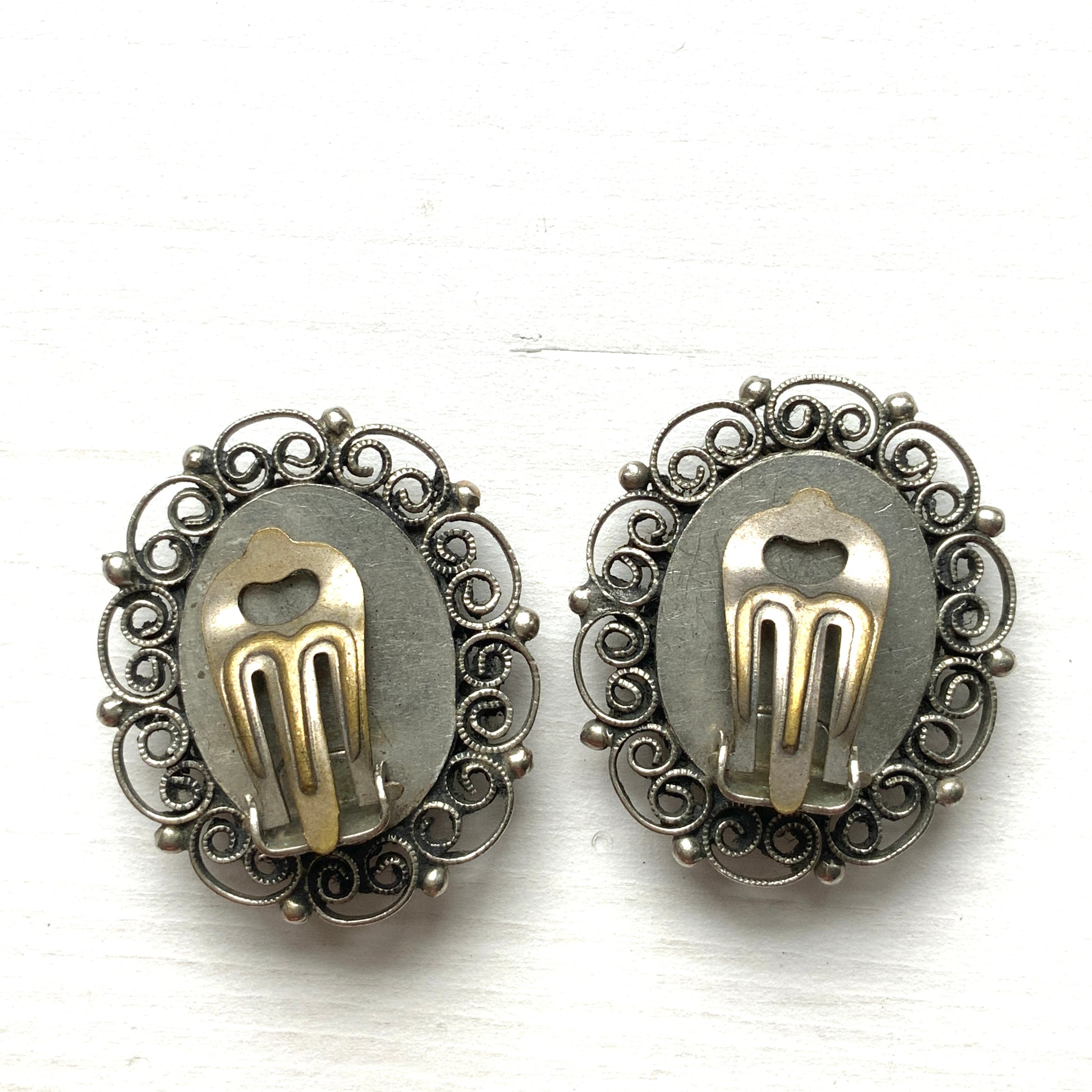 These clip-on earrings feature a beautifully detailed micro mosaic framed with silver-tone filigree that resembles delicate lace. シルバートーン のフィリグリーがまるでレースのように縁にあしらわれたマイクロモザイク のクリップイヤリング。