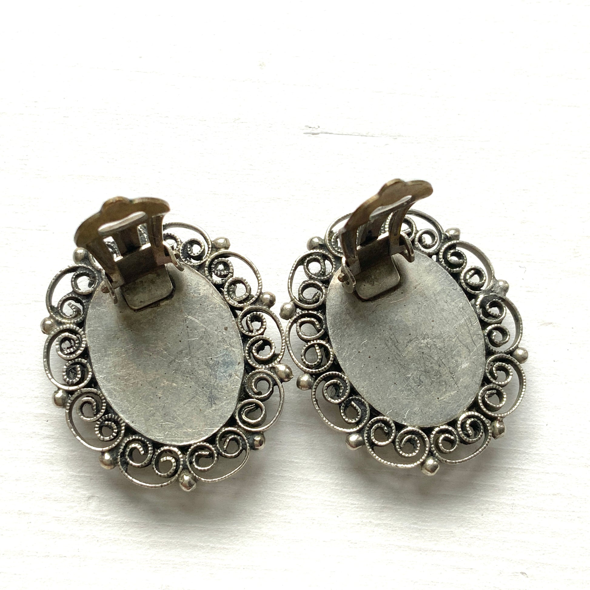 These clip-on earrings feature a beautifully detailed micro mosaic framed with silver-tone filigree that resembles delicate lace. シルバートーン のフィリグリーがまるでレースのように縁にあしらわれたマイクロモザイク のクリップイヤリング。