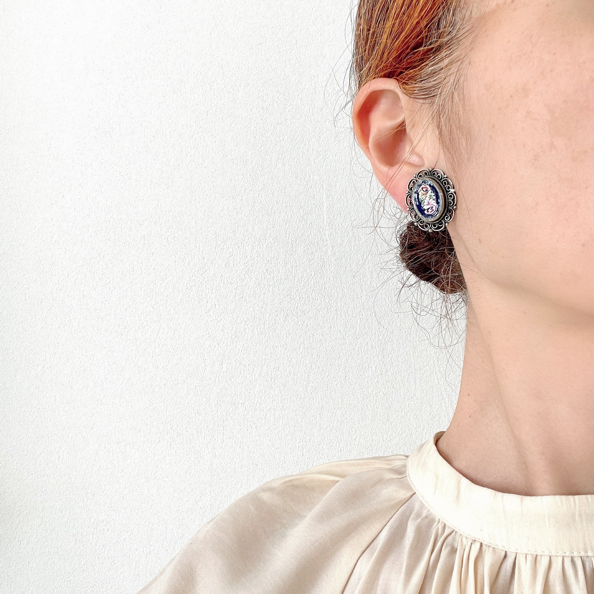 These clip-on earrings feature a beautifully detailed micro mosaic framed with silver-tone filigree that resembles delicate lace. シルバートーン のフィリグリーがまるでレースのように縁にあしらわれたマイクロモザイク のクリップイヤリング。